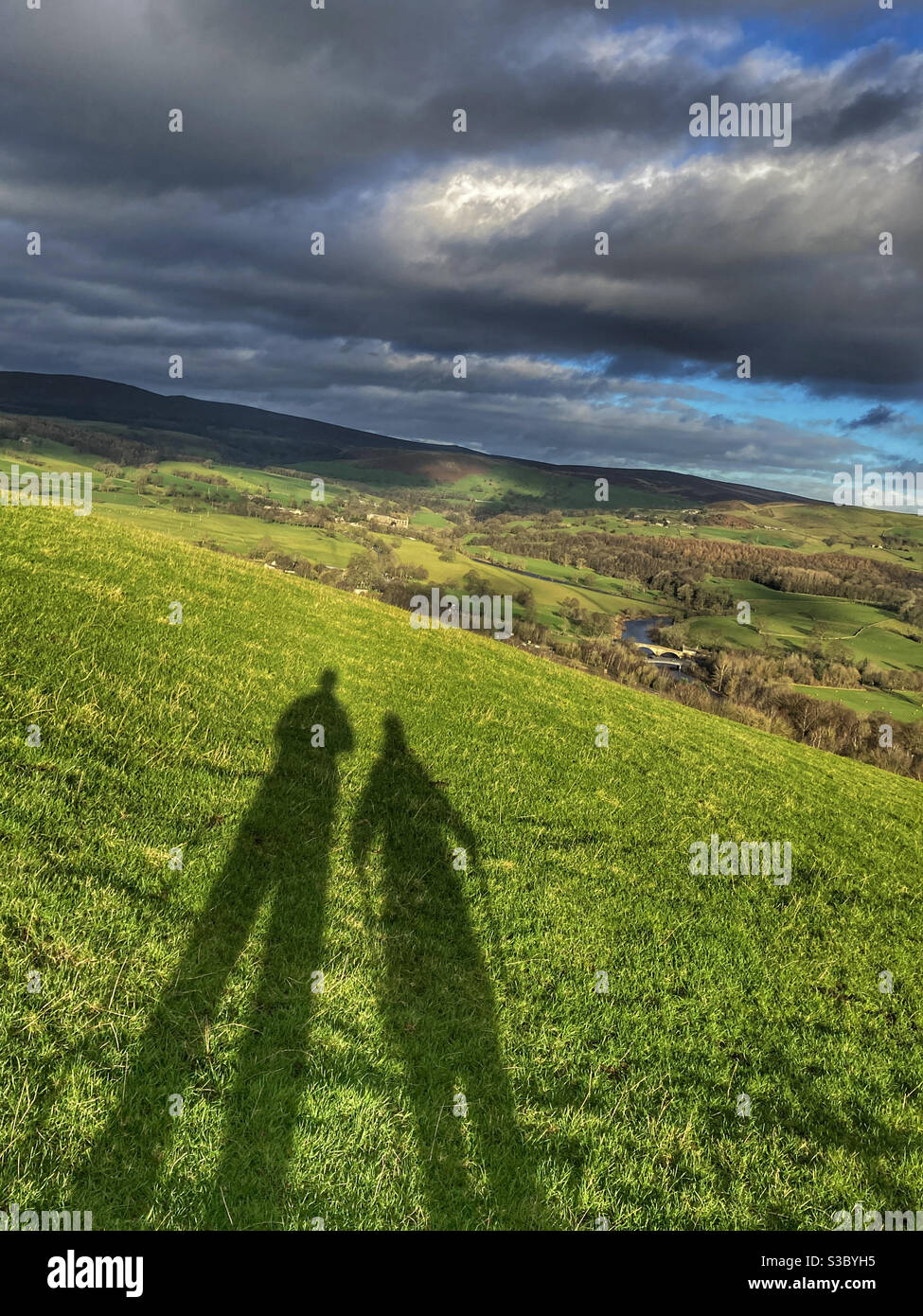 Ombra di due escursionisti su Haw Pike ammirando la vista Guardando verso Bolton Abbey North Yorkshire - Immagine stock catturata con smartphone