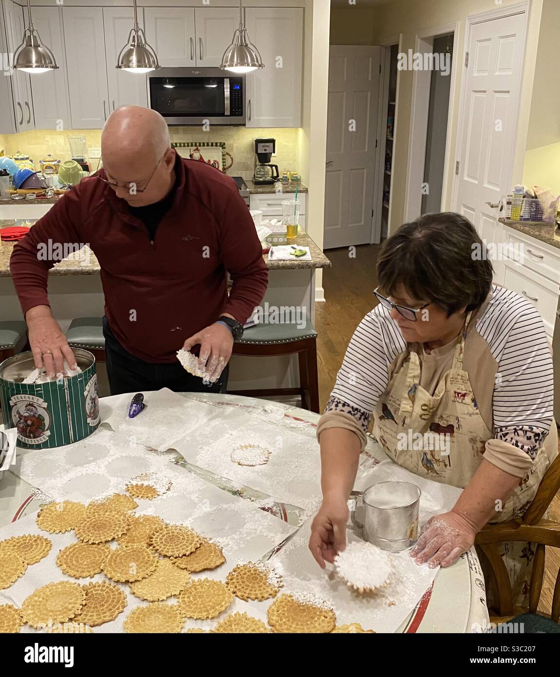 Una coppia sposata che fa biscotti delle pizzelle per le feste di Natale Foto Stock