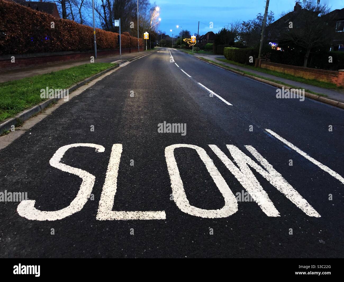 Un segno di rallentamento dipinto su una strada cittadina - Immagine stock catturata con smartphone