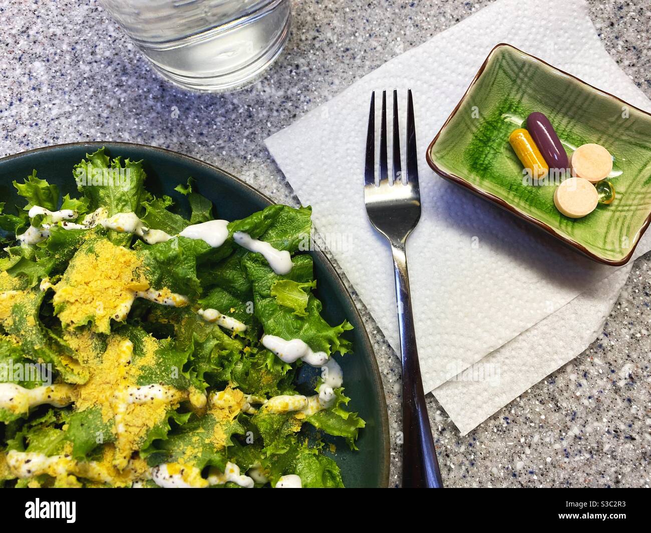 Un'insalata e un piatto di pillole di vitamina. Foto Stock