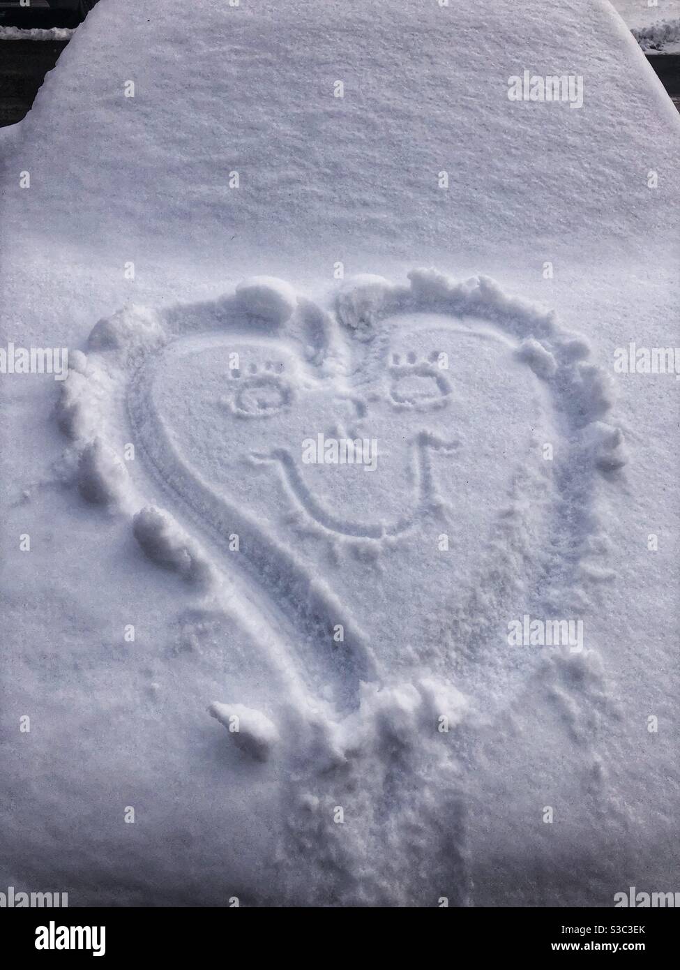 Un cuore sorridente disegnato nella neve. Foto Stock