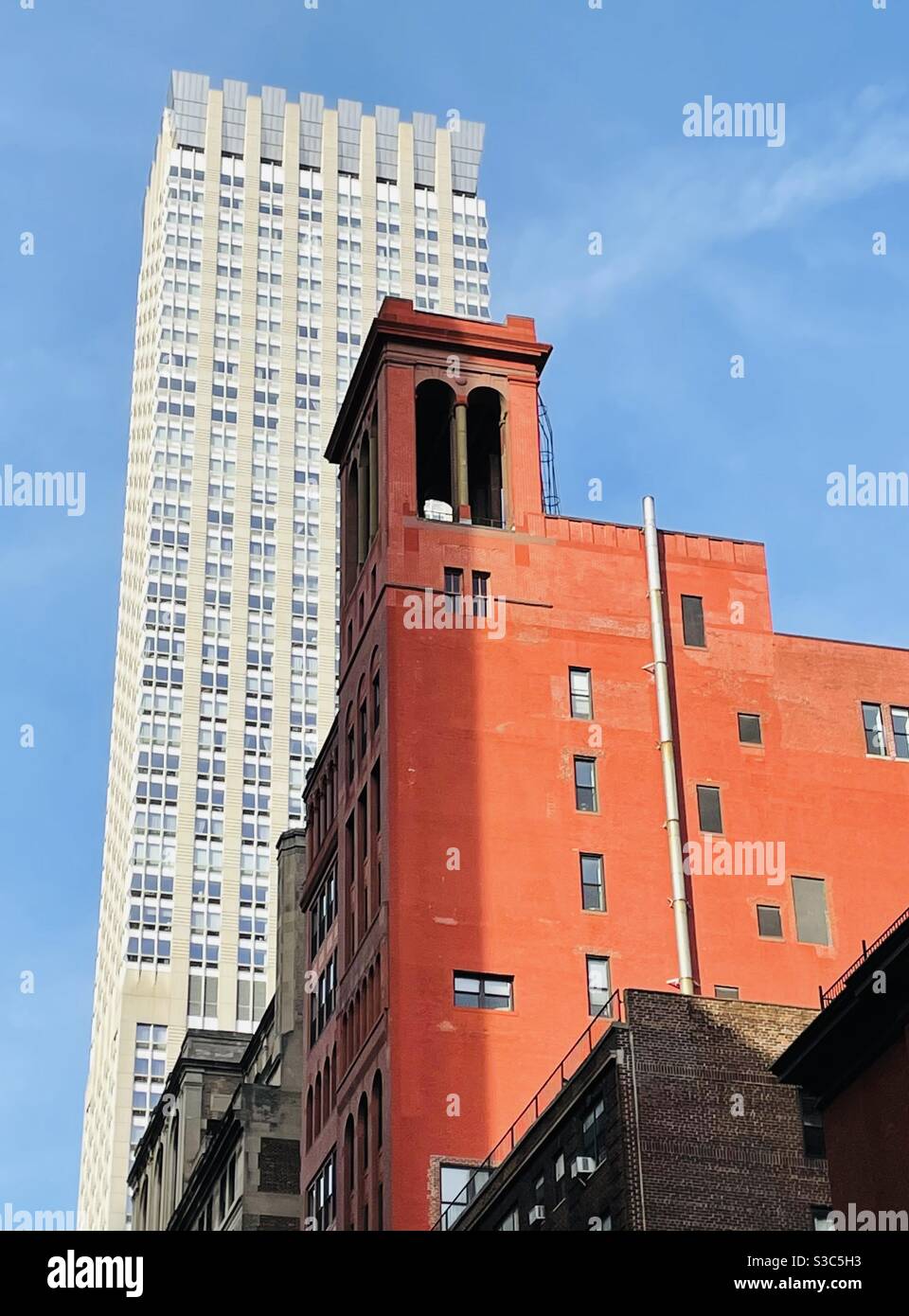 Il sole del pomeriggio esalta le colorate sfumature dei grattacieli nel centro di Manhattan e mette in risalto l'edificio del condominio Morgan Lofts in mattoni rossi, 11 East 35th Street vicino a Madison Ave costruito nel 1912. Foto Stock