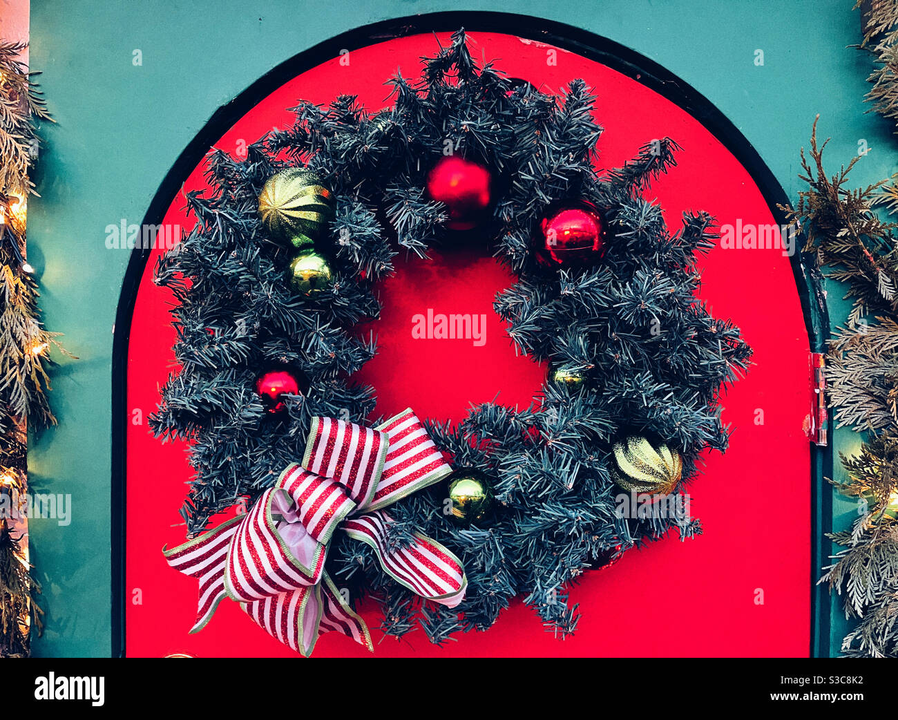 Ghirlanda di Natale sulla porta rossa Foto Stock