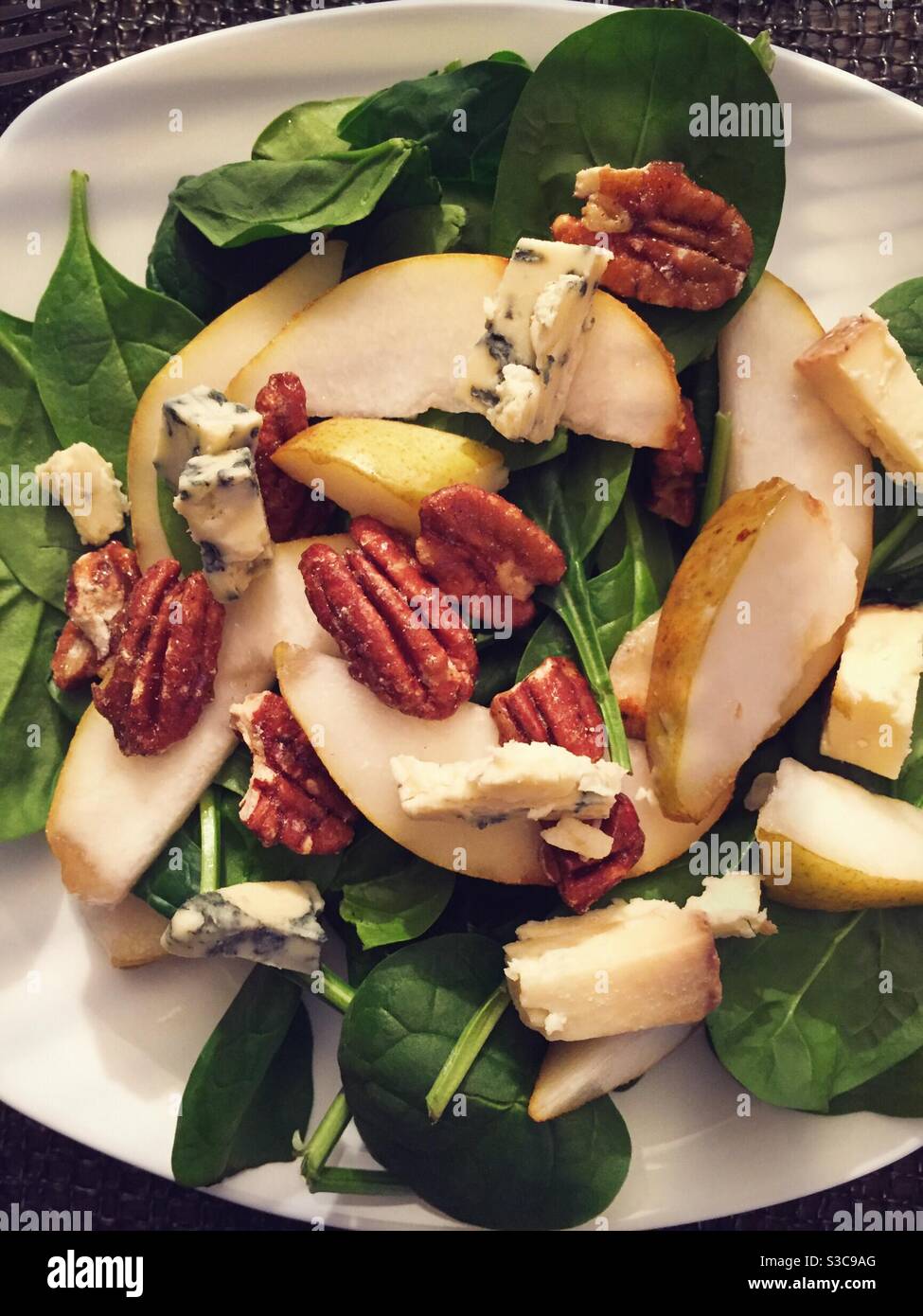 Piatto di un'insalata gourmet di formaggio Stilton, pere fresche e pecan canditi su un letto di verdure. Foto Stock