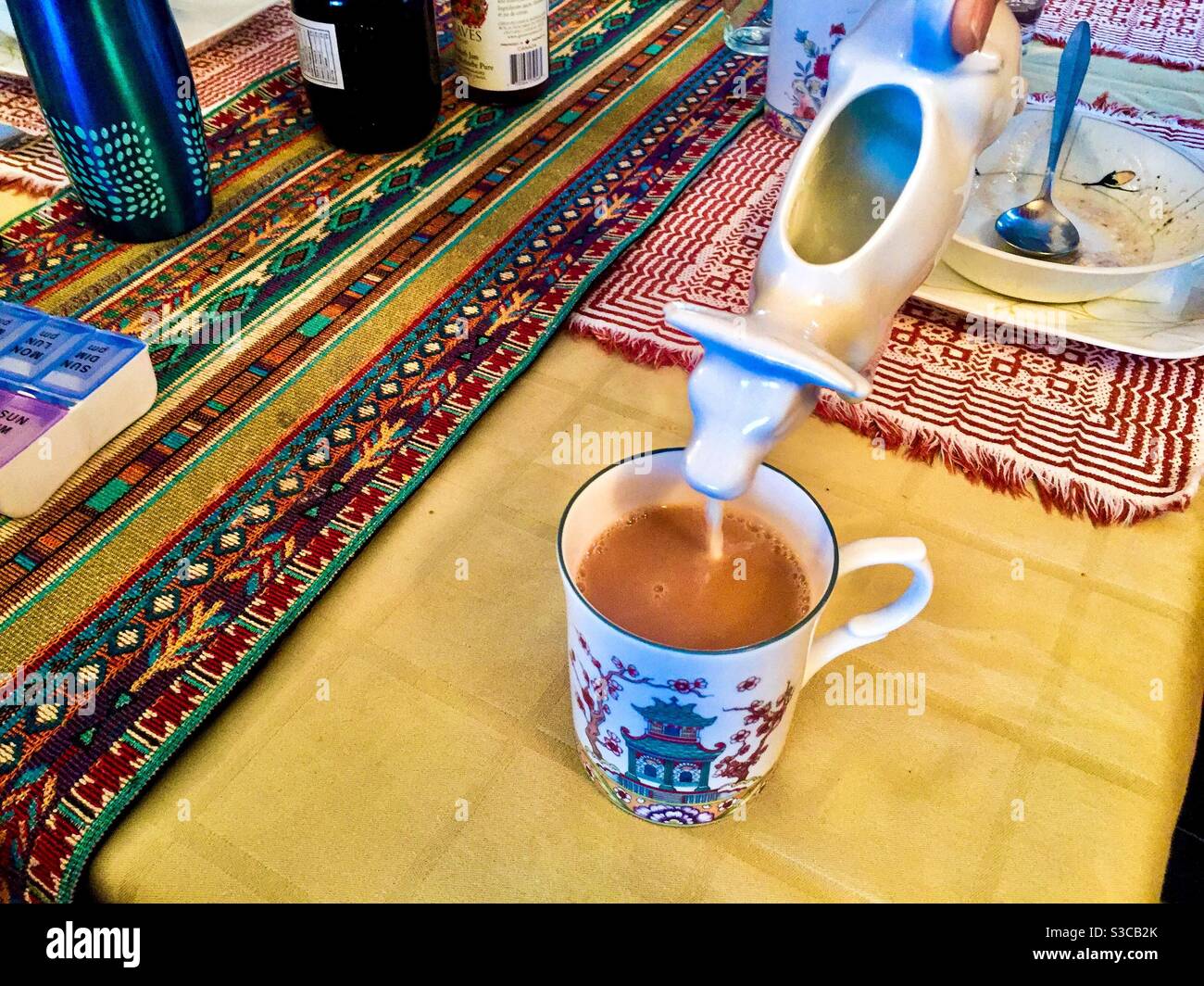 Latte per il tè, fresco da una mucca nutrita d'erba, che si allontana da un elegante contenitore in un elegante tavolo, il Canada Foto Stock