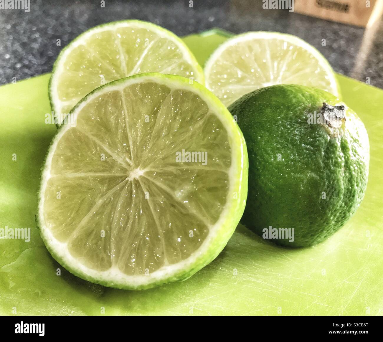 Taglia i lime su una tagliere Foto Stock
