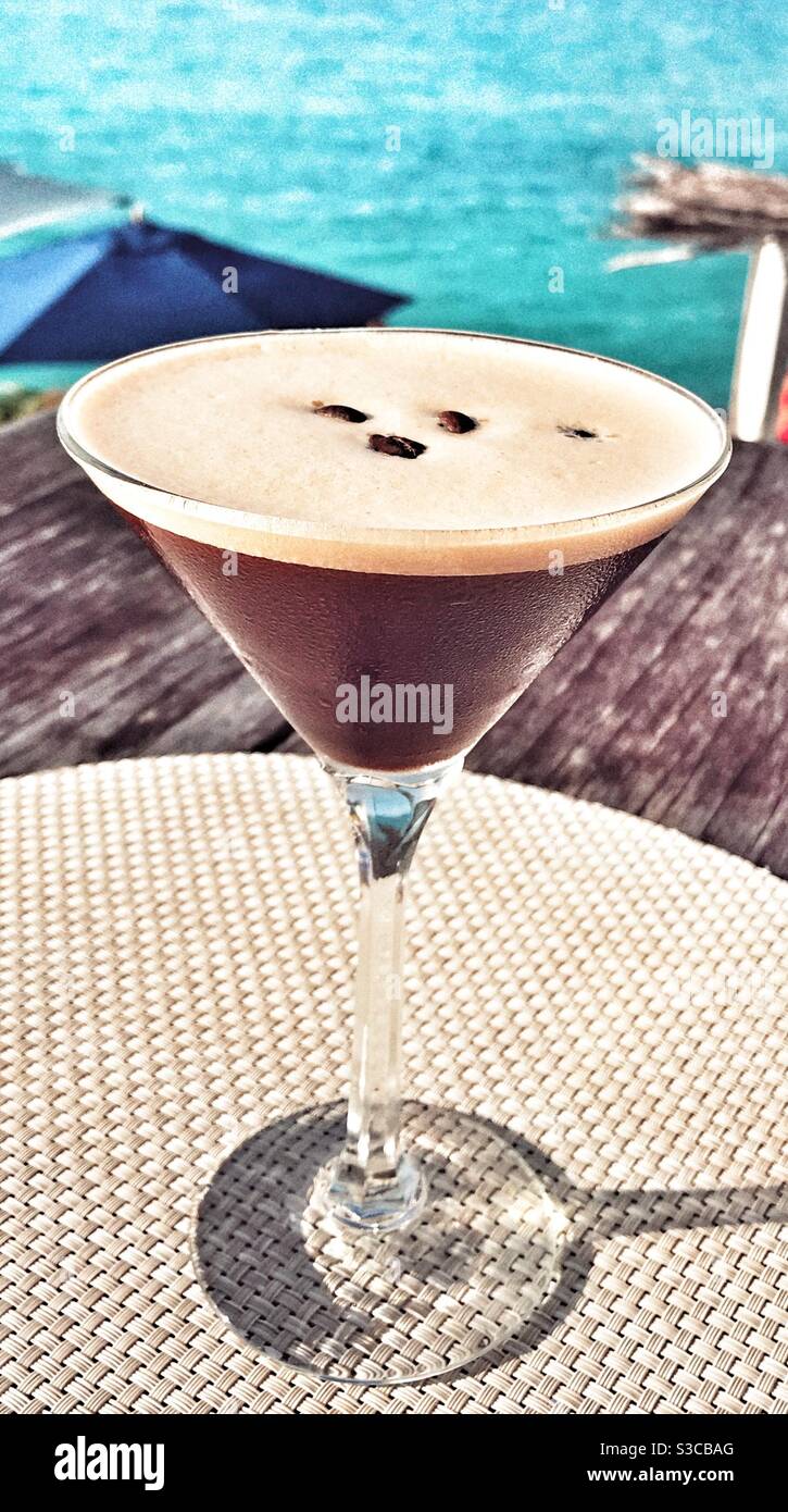 Espresso Martini su un tavolo con il Mar dei Caraibi alle spalle Foto Stock