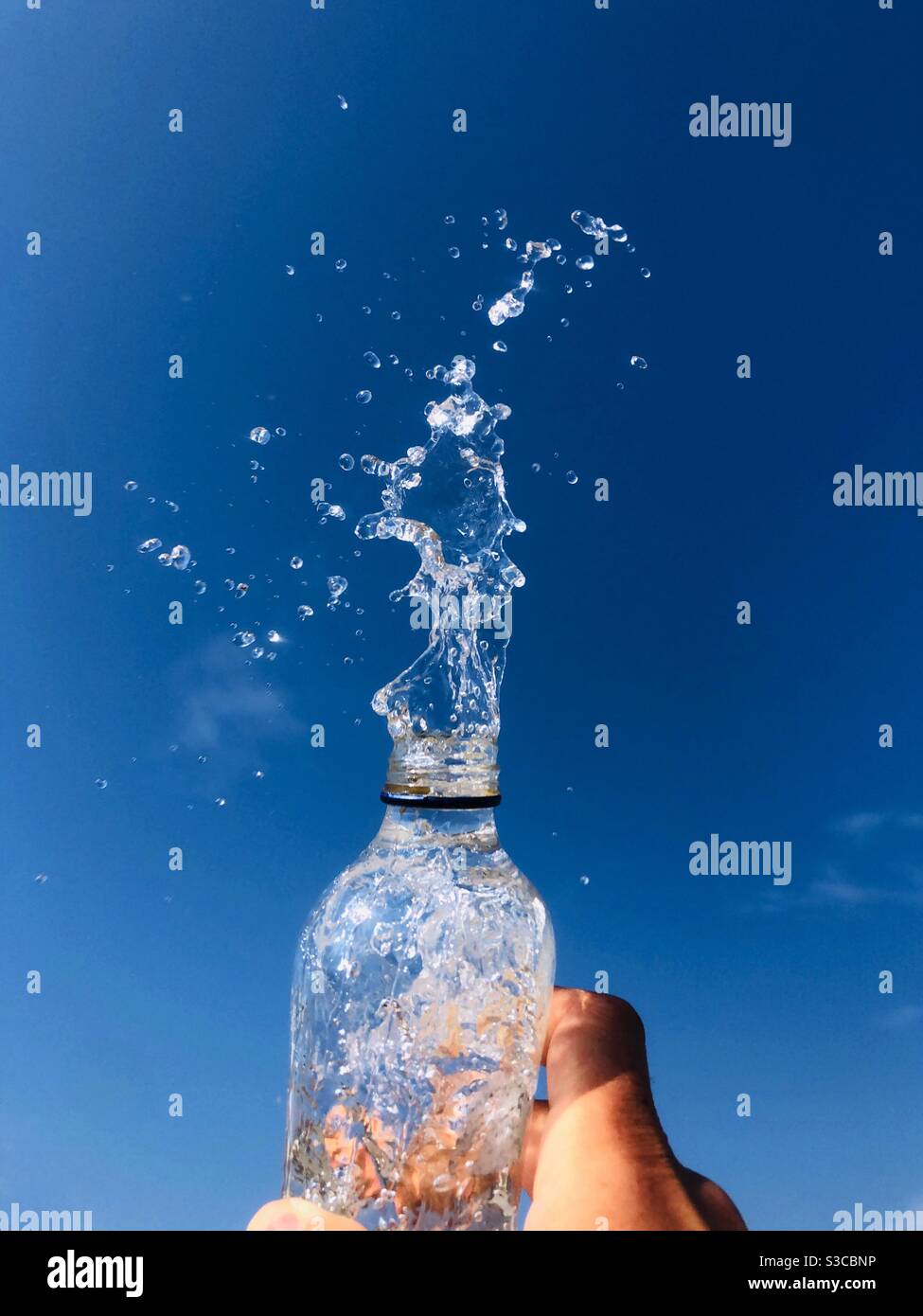 Spruzzi d'acqua da una bottiglia di vetro Foto Stock