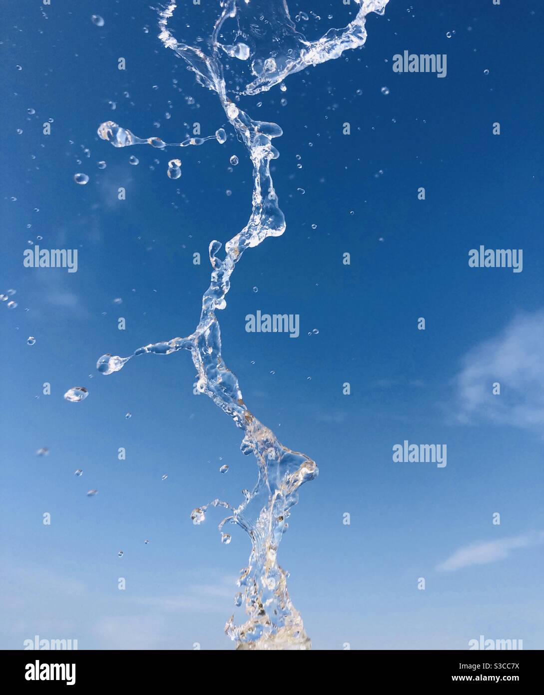 Spruzzi d'acqua contro il cielo blu - Immagine stock catturata con smartphone