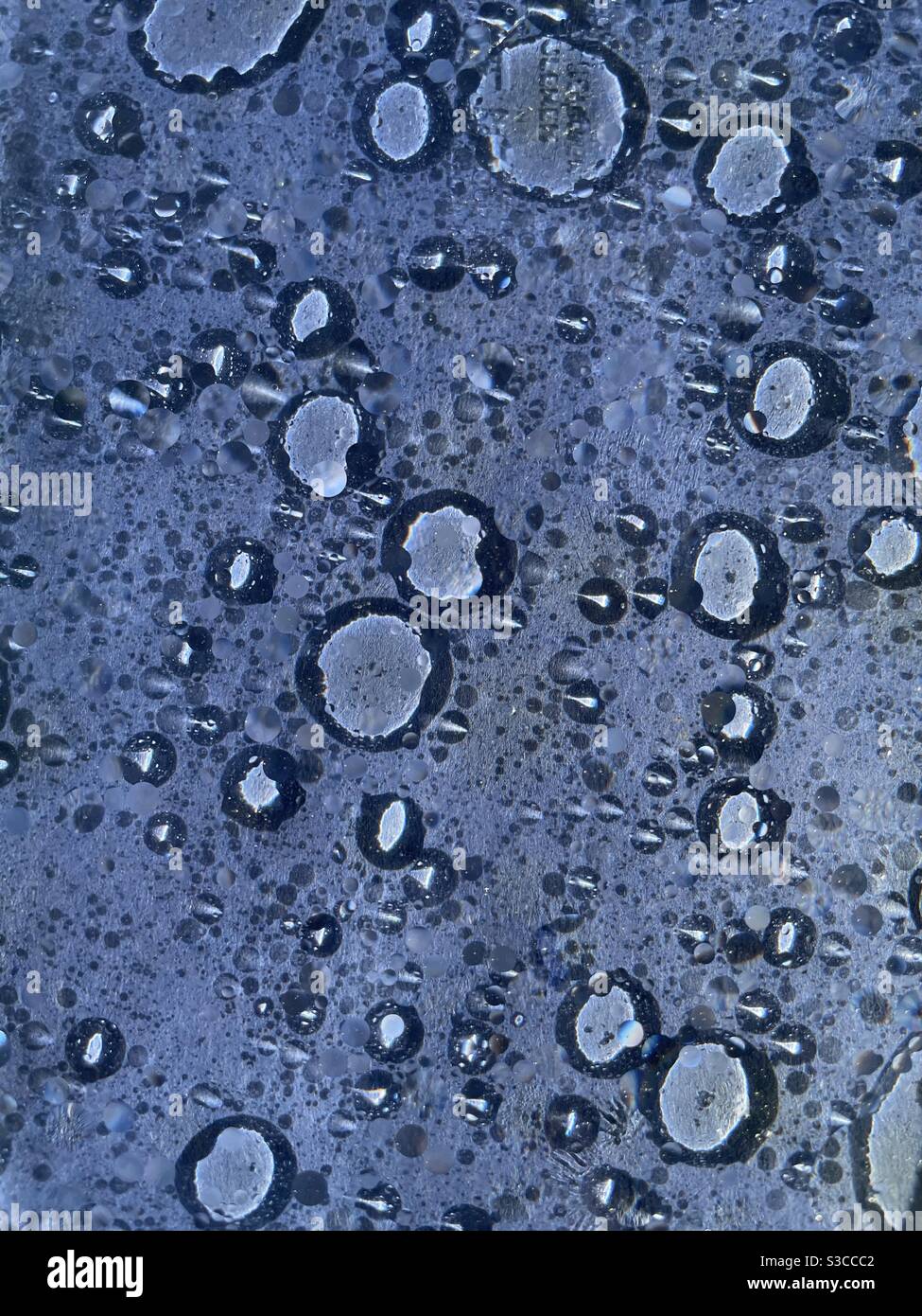 Olio astratto e bolle d'acqua su sfondo blu Foto Stock
