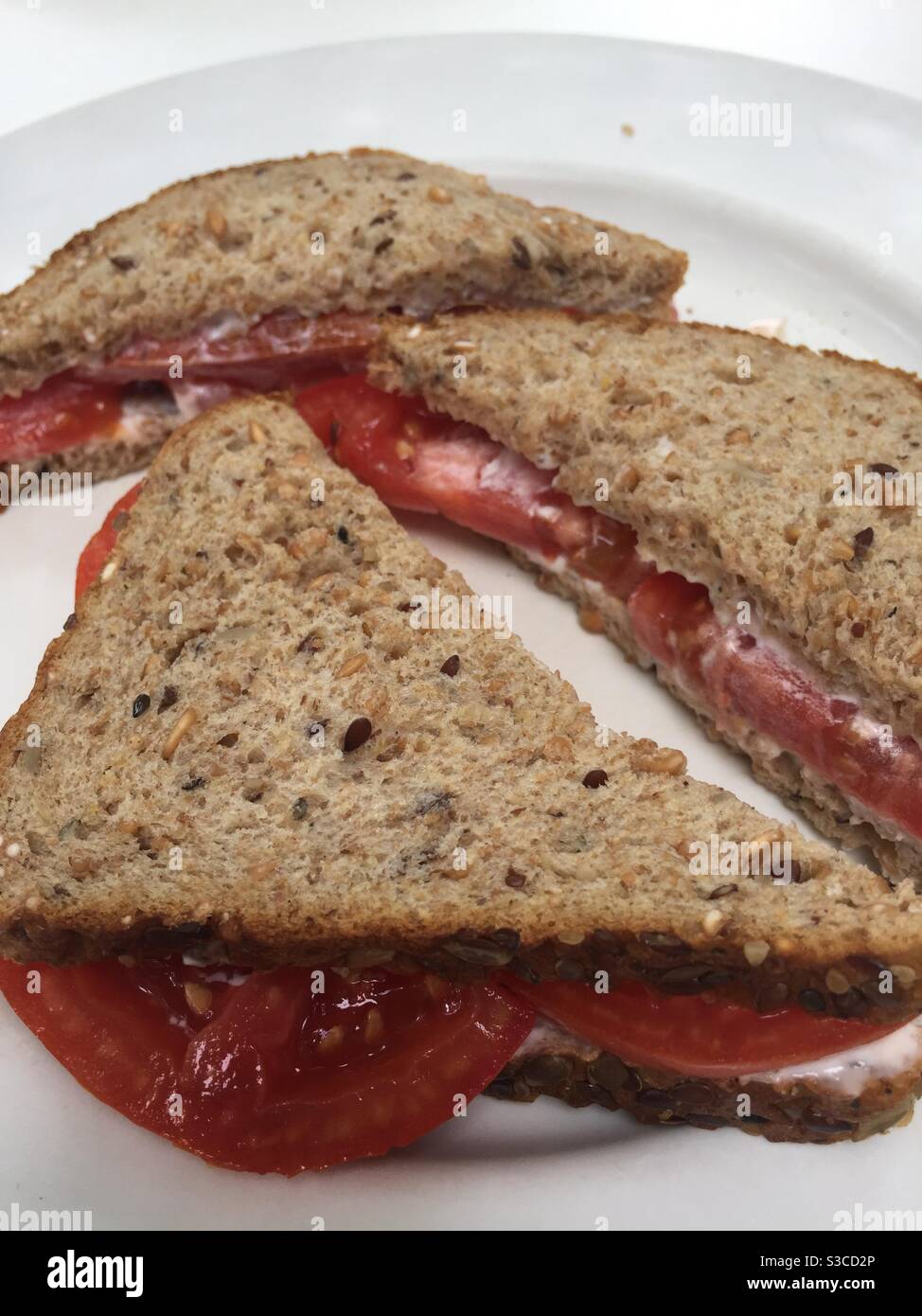 Sandwich di pomodoro con maionese su pane a grani interi. Foto Stock