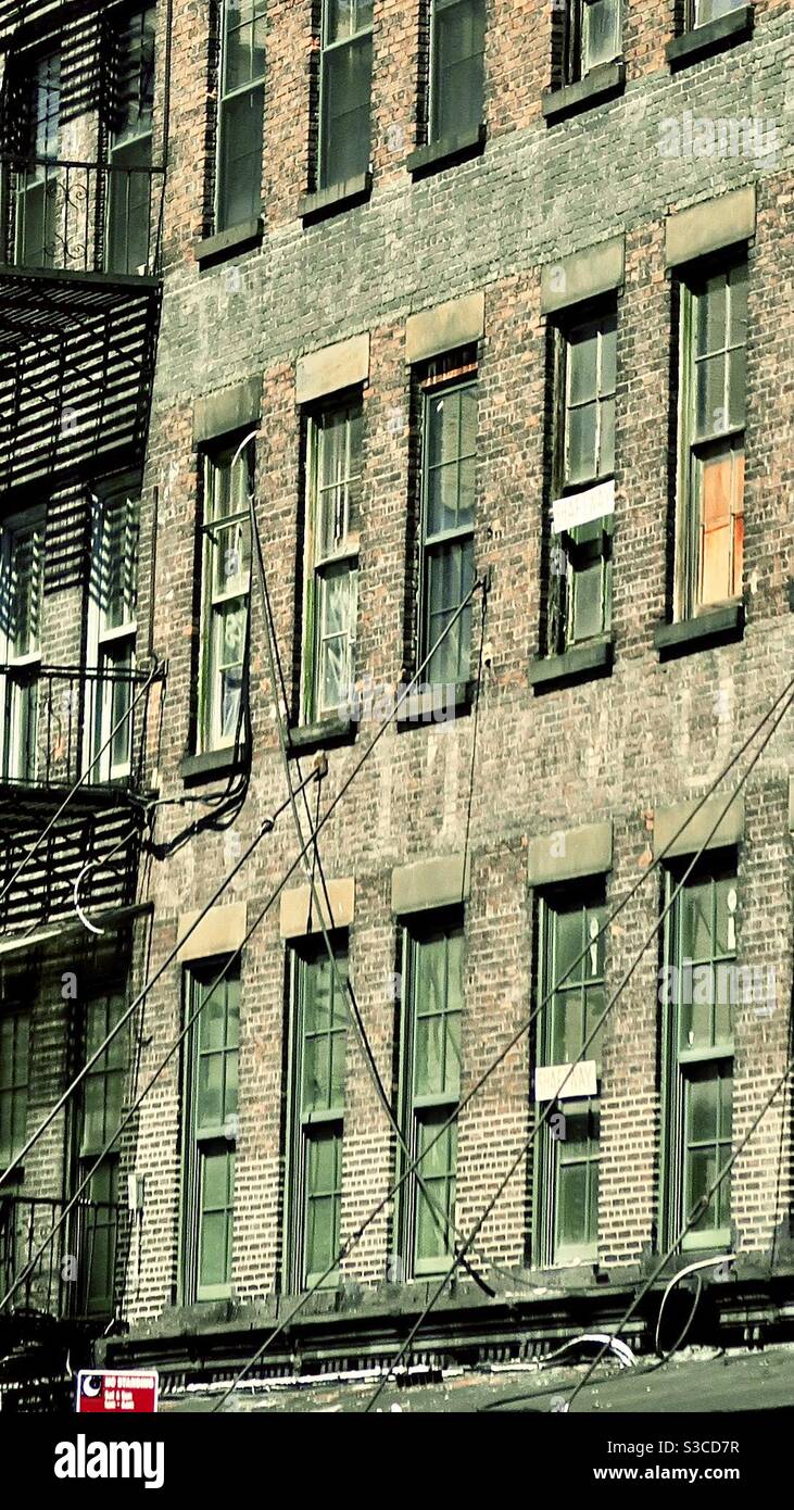 Quartiere povero, povero e privato di Manhattan New York City USA. Un edificio in mattoni di appartamenti e appartamenti con scappamento in metallo con finestre schiacciate e salite a New York Foto Stock