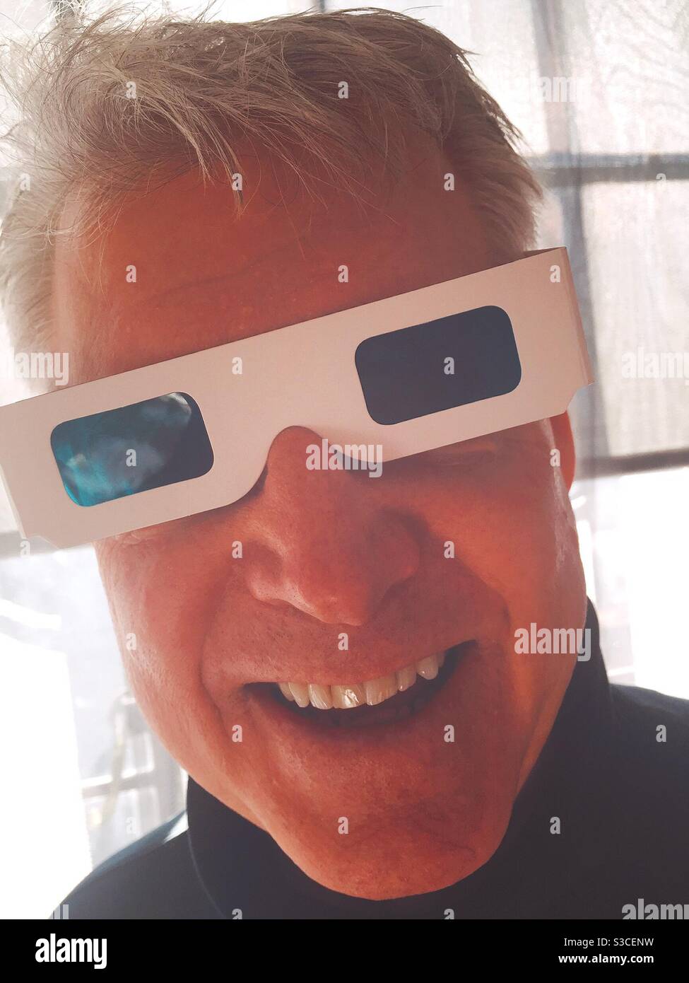 Uomo anziano che indossa occhiali 3-D in cartone sorridente e guardando la fotocamera, Stati Uniti Foto Stock