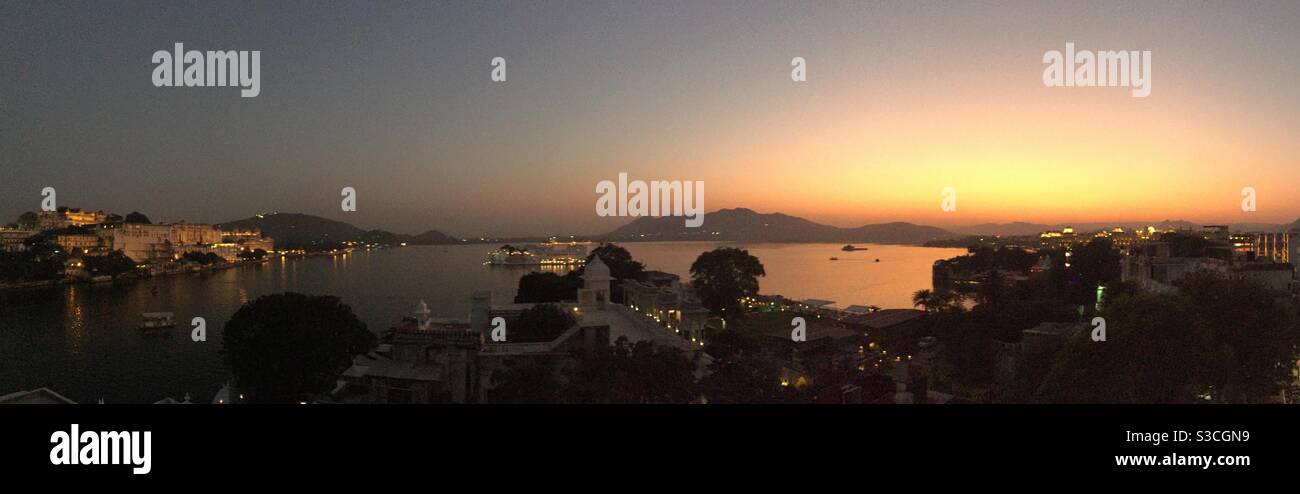 Impostazione del sole che guarda sul lago di Pichola in Udaipur Rajasthan India Foto Stock