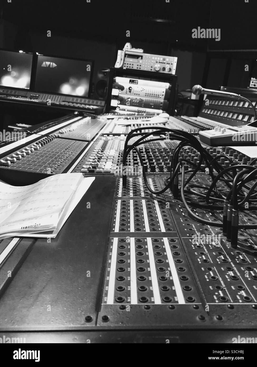 Ripresa di uno studio musicale con un primo piano della console di mixaggio. Console di mixaggio del suono in bianco e nero. Foto Stock