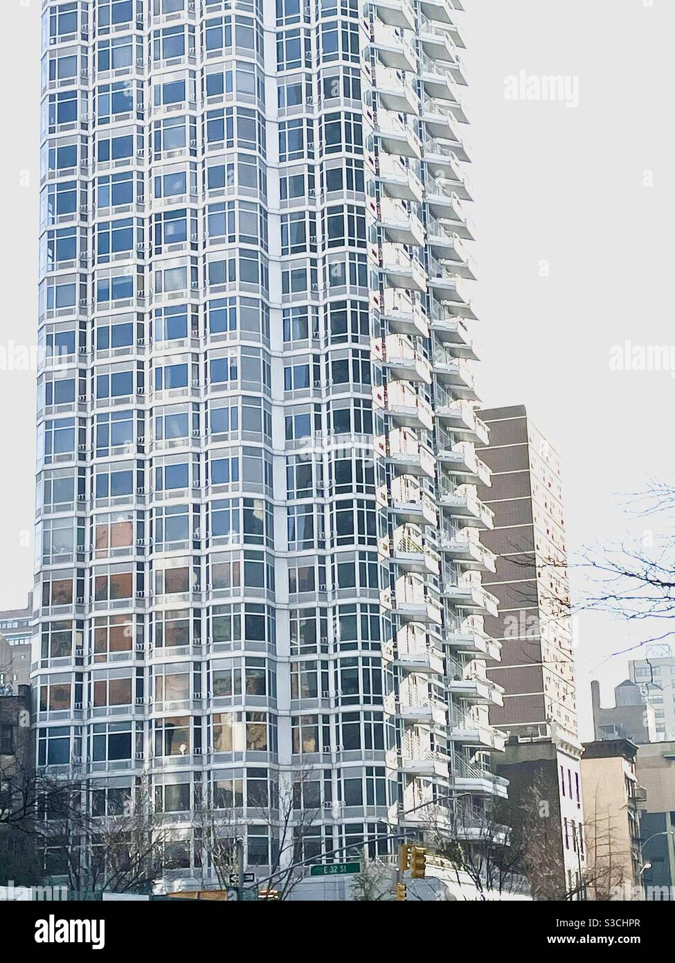 Questo raschietto cielo residenziale di East Side New York City brilla come un intricato disegno grafico di luce e ombra, colore e stordità con balconi e finestre perfettamente allineati - Immagine stock catturata con smartphone