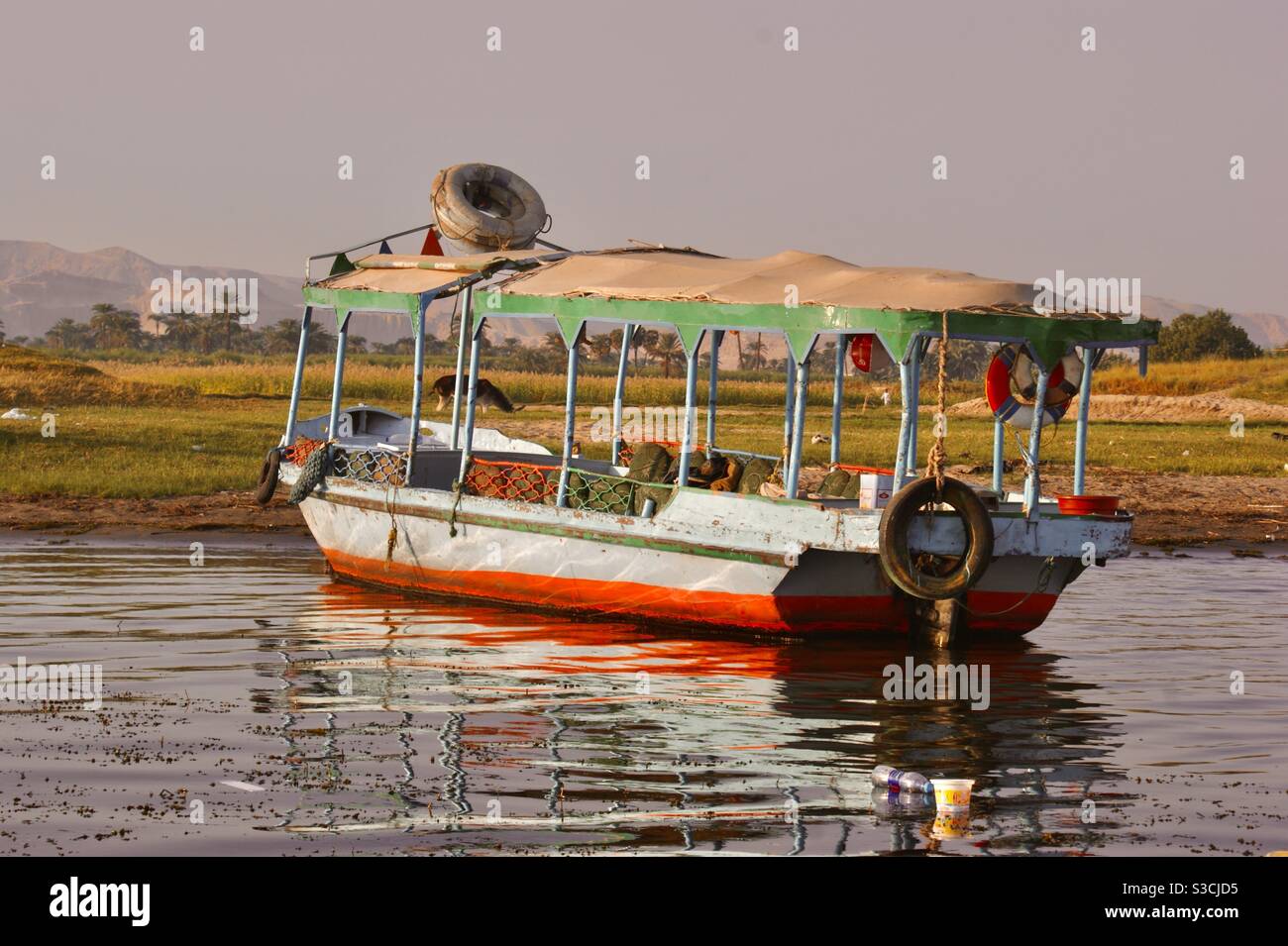 Colorata barca vuota per passeggeri che galleggia sul fiume Nilo, Egitto, Africa al tramonto Foto Stock