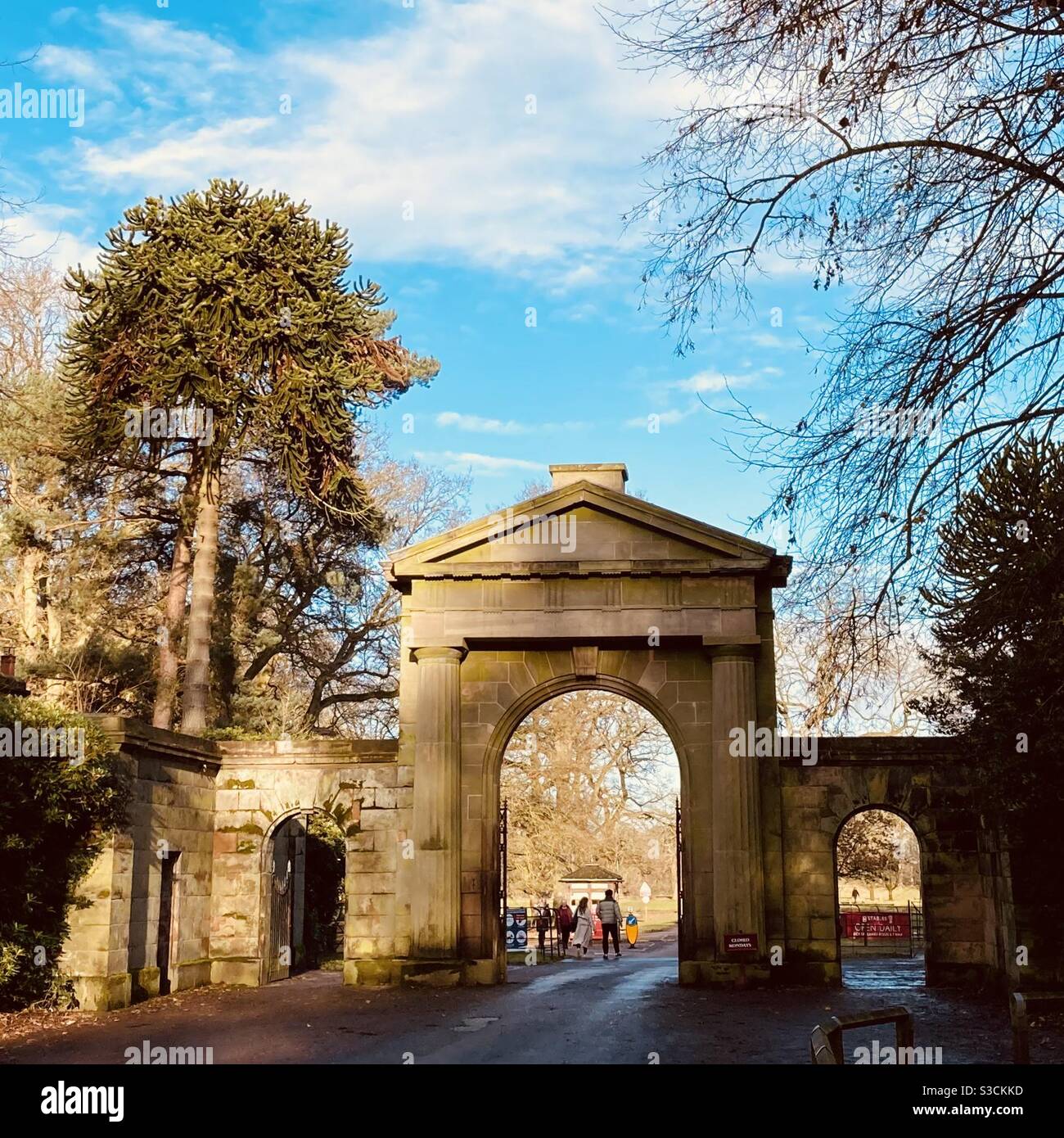 Camminatori al cancello in pietra ad arco ingresso al Tatton Park Knutsford Cheshire Foto Stock