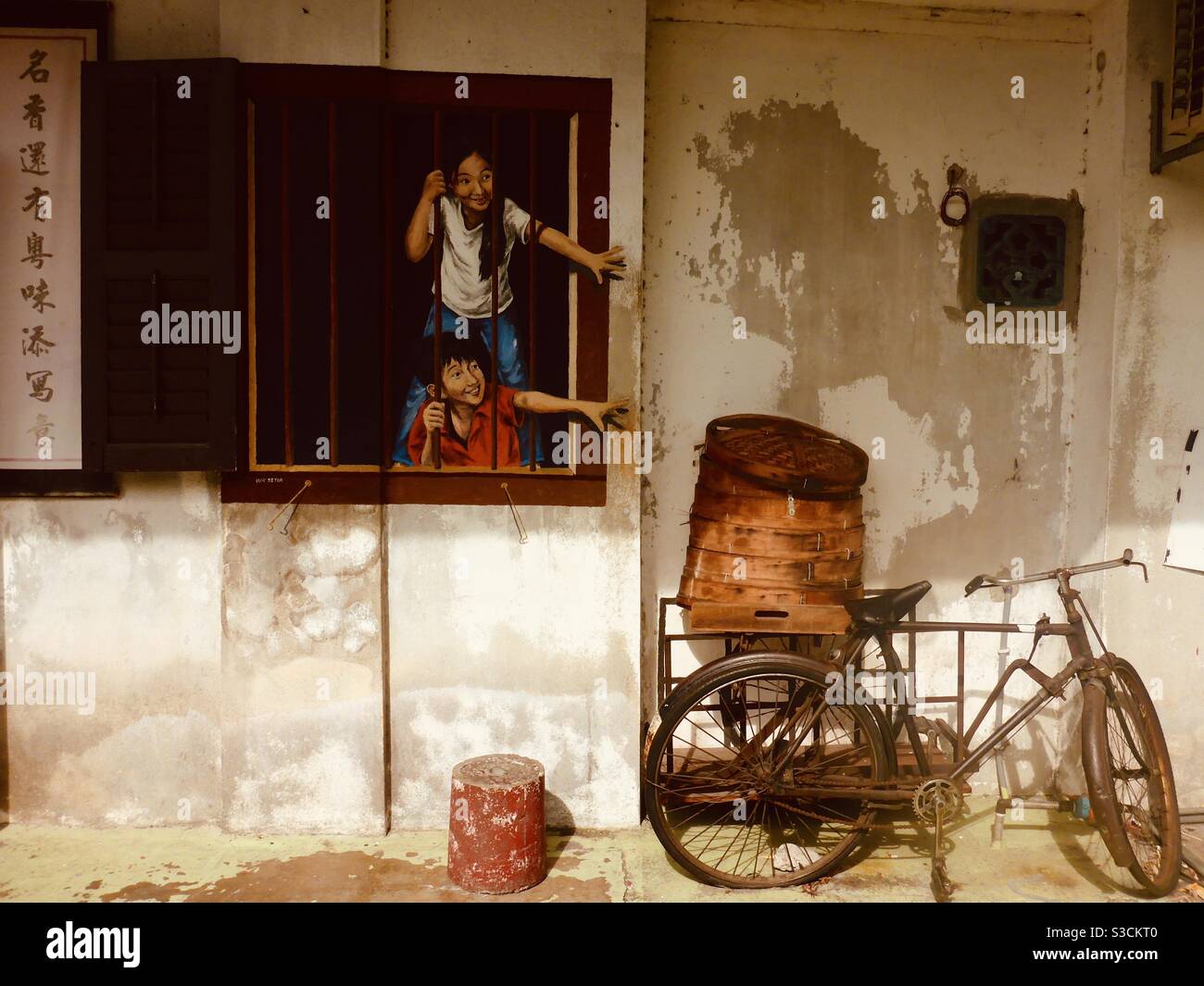Bambini dietro Window Bar Street art a Georgetown Penang Malesia - Immagine stock catturata con smartphone