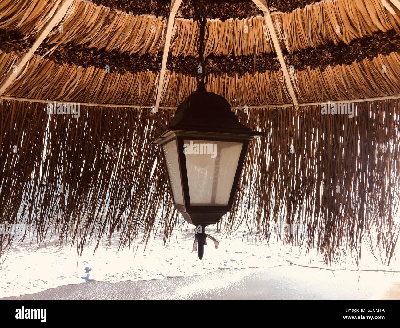 Lampadario in un capannone di paglia vicino al mare - Immagine stock catturata con smartphone