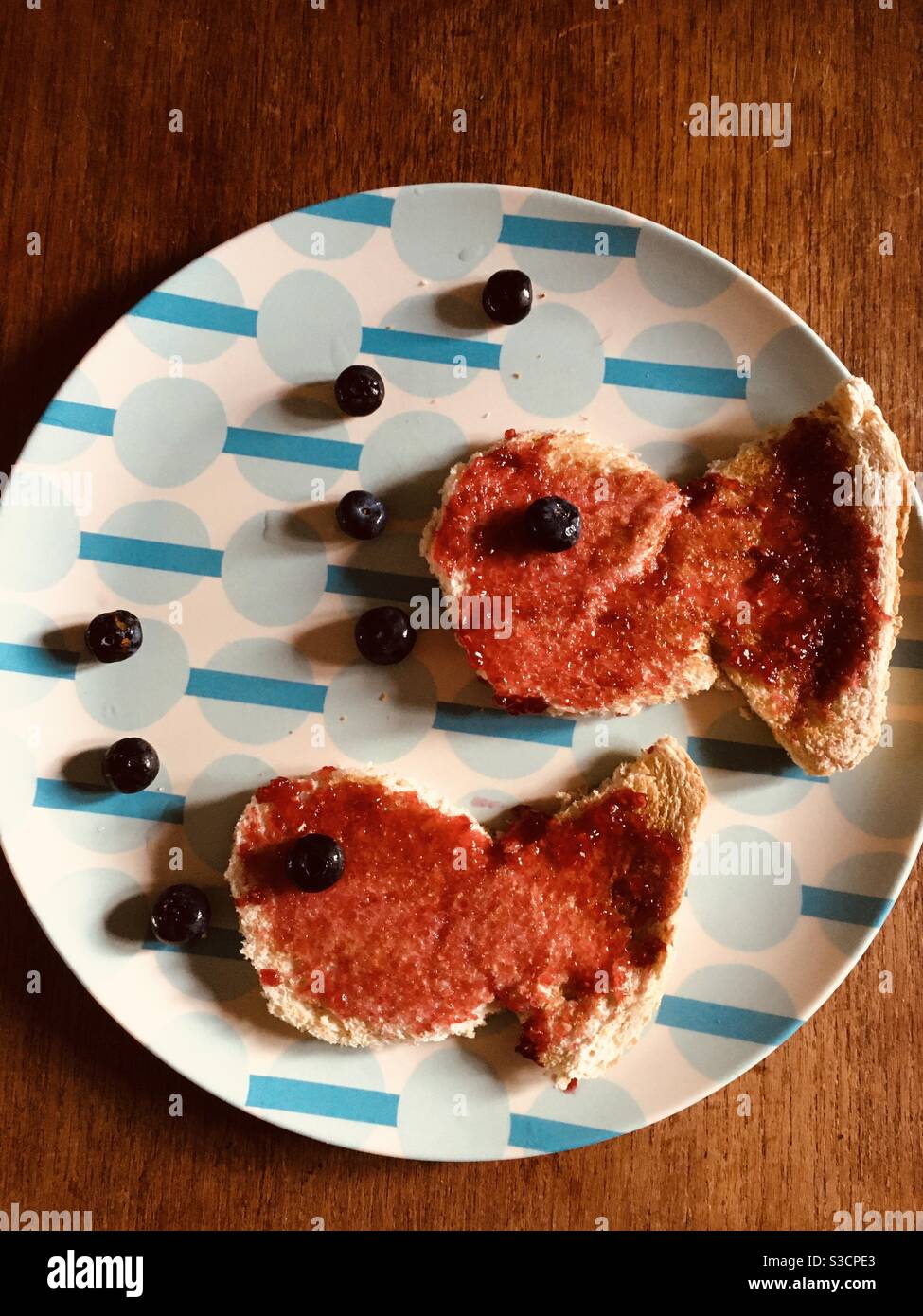 Marmellata su pane tostato con mirtilli fatti in una foto di pesce Foto Stock