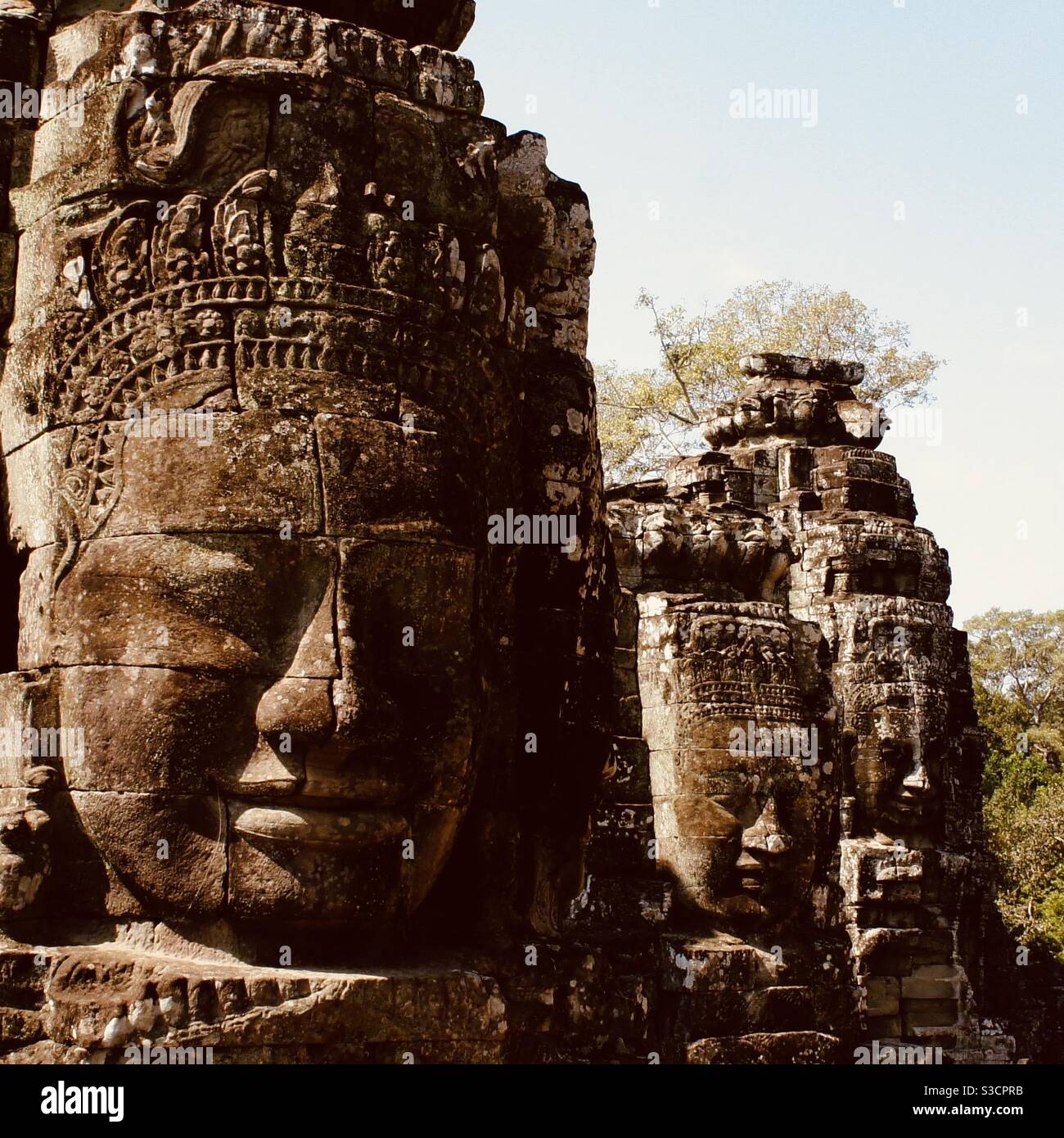 Sorridente facce di pietra al tempio di Bayon Angkor Wat Cambogia - Immagine stock catturata con smartphone