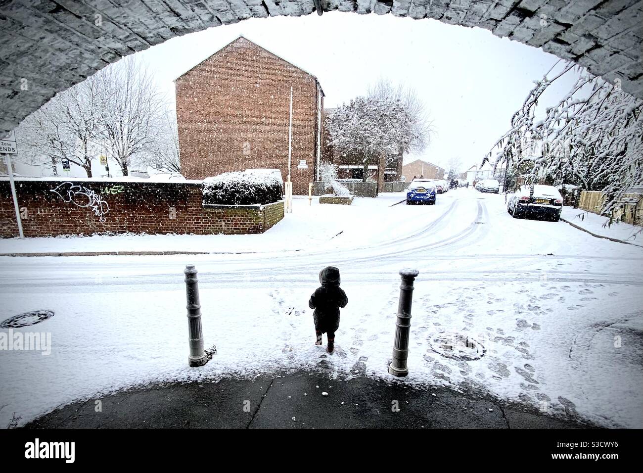 Bambino nella neve sotto un tunnel Foto Stock