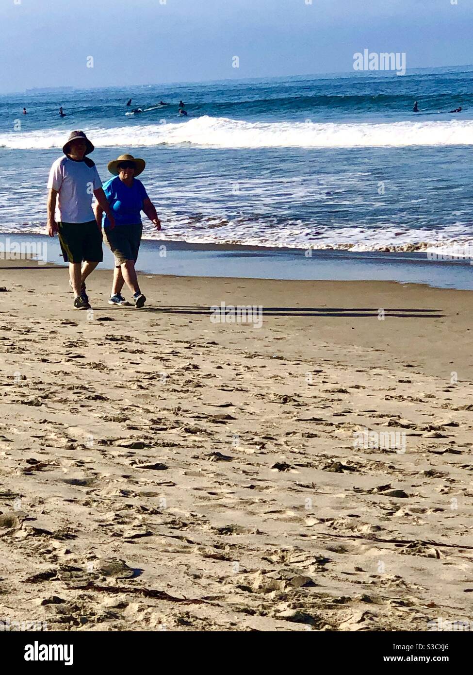Queste due persone che camminano lungo la riva di Santa Monica, California, mostrano quanto sia piacevole sviluppare abitudini sane e utilizzare il sistema di amici! - Immagine stock catturata con smartphone