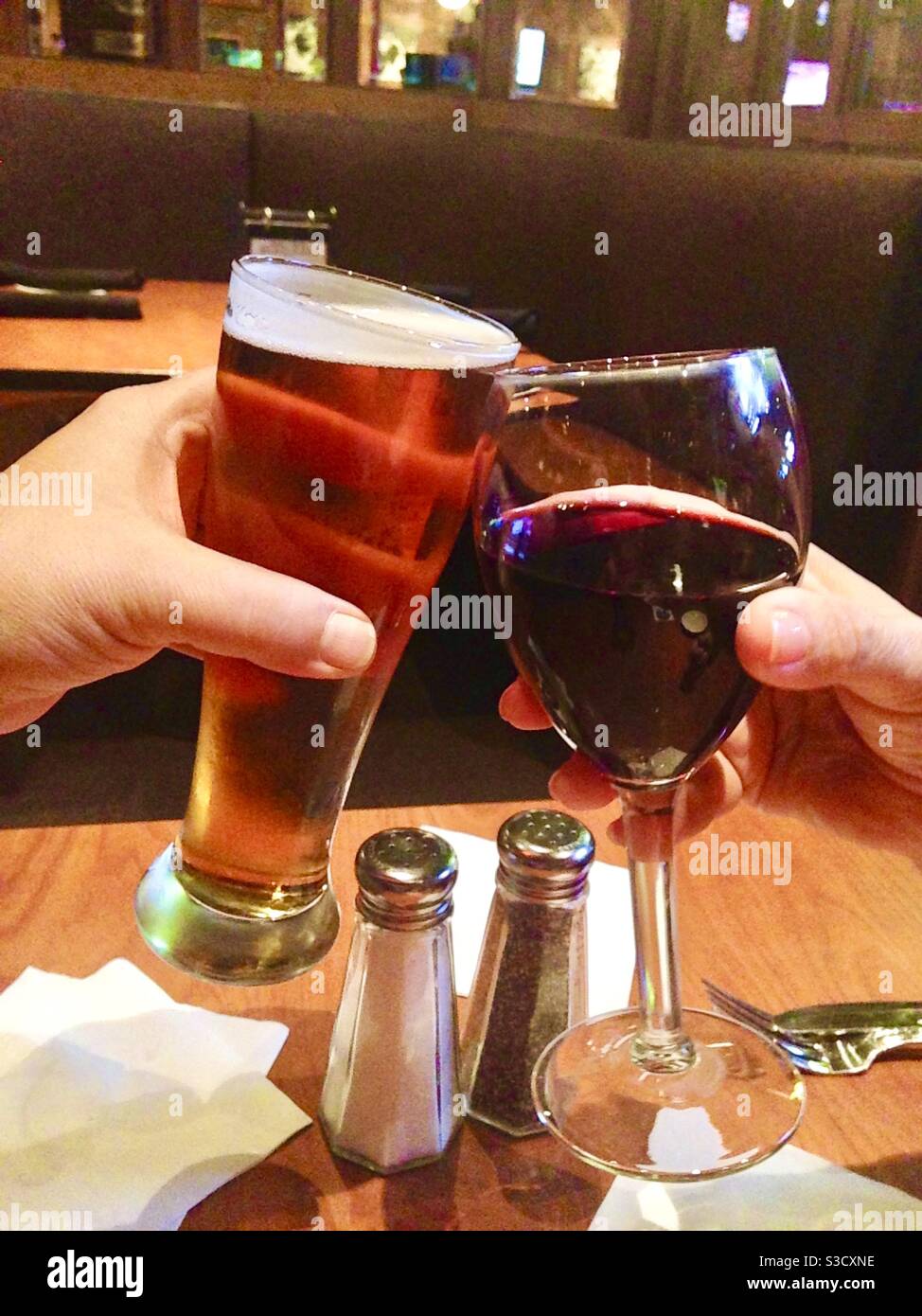 Grazie! In qualsiasi lingua, la buona volontà è la stessa che noi applichiamo i nostri bicchieri di bevande come questa coppia fa con una birra e un vino rosso. - Immagine stock catturata con smartphone