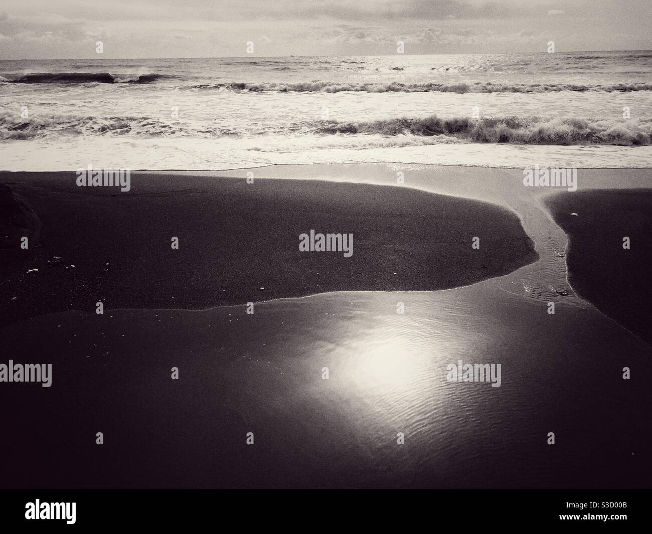 Paesaggio marino di una spiaggia e riflesso del sole su acqua Foto Stock