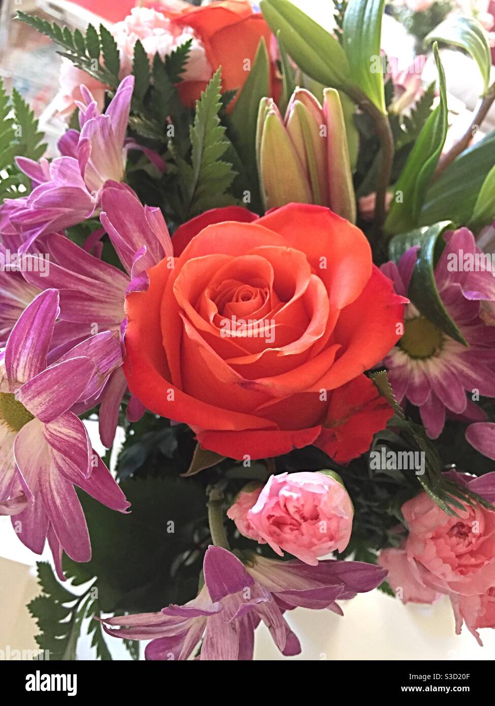 Primo piano di un bouquet di fiori con un completamente rosa rossa aperta Foto Stock