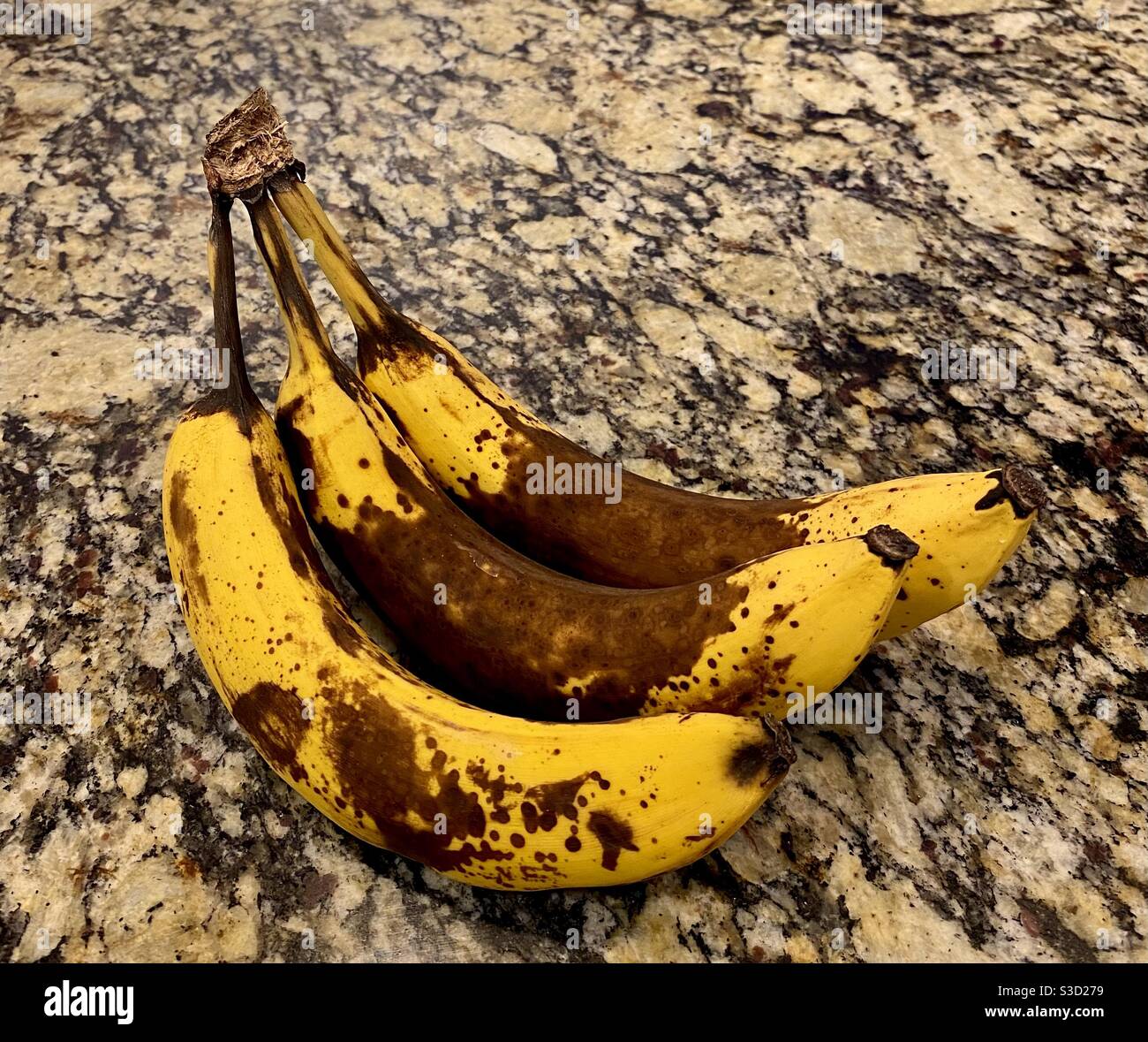 Banane sopramature che posano su bancone di granito Foto Stock