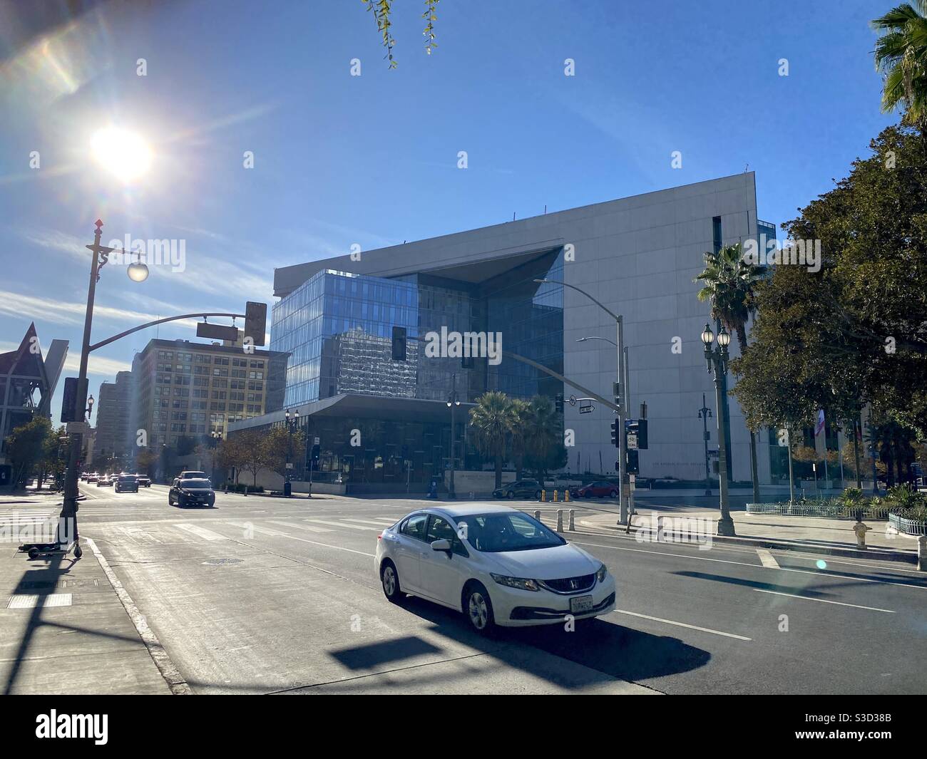 LOS ANGELES, CA, NOVEMBRE 2020: Ampia vista della sede centrale del Dipartimento di polizia di Los Angeles in centro con traffico che passa in primo piano e sole con lenti svasate Foto Stock
