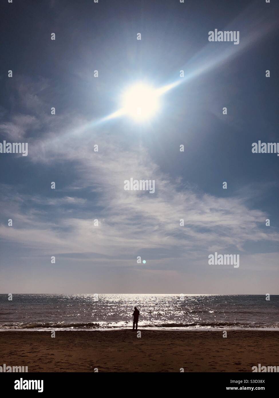 Uomo in piedi sul mare in una giornata di sole Foto Stock