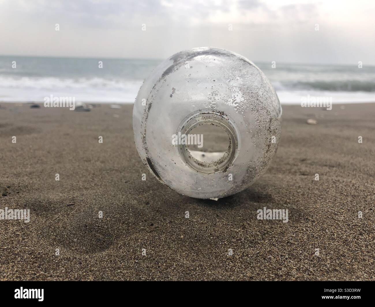 Bottiglia di plastica lasciata sulla spiaggia causando inquinamento - Immagine stock catturata con smartphone