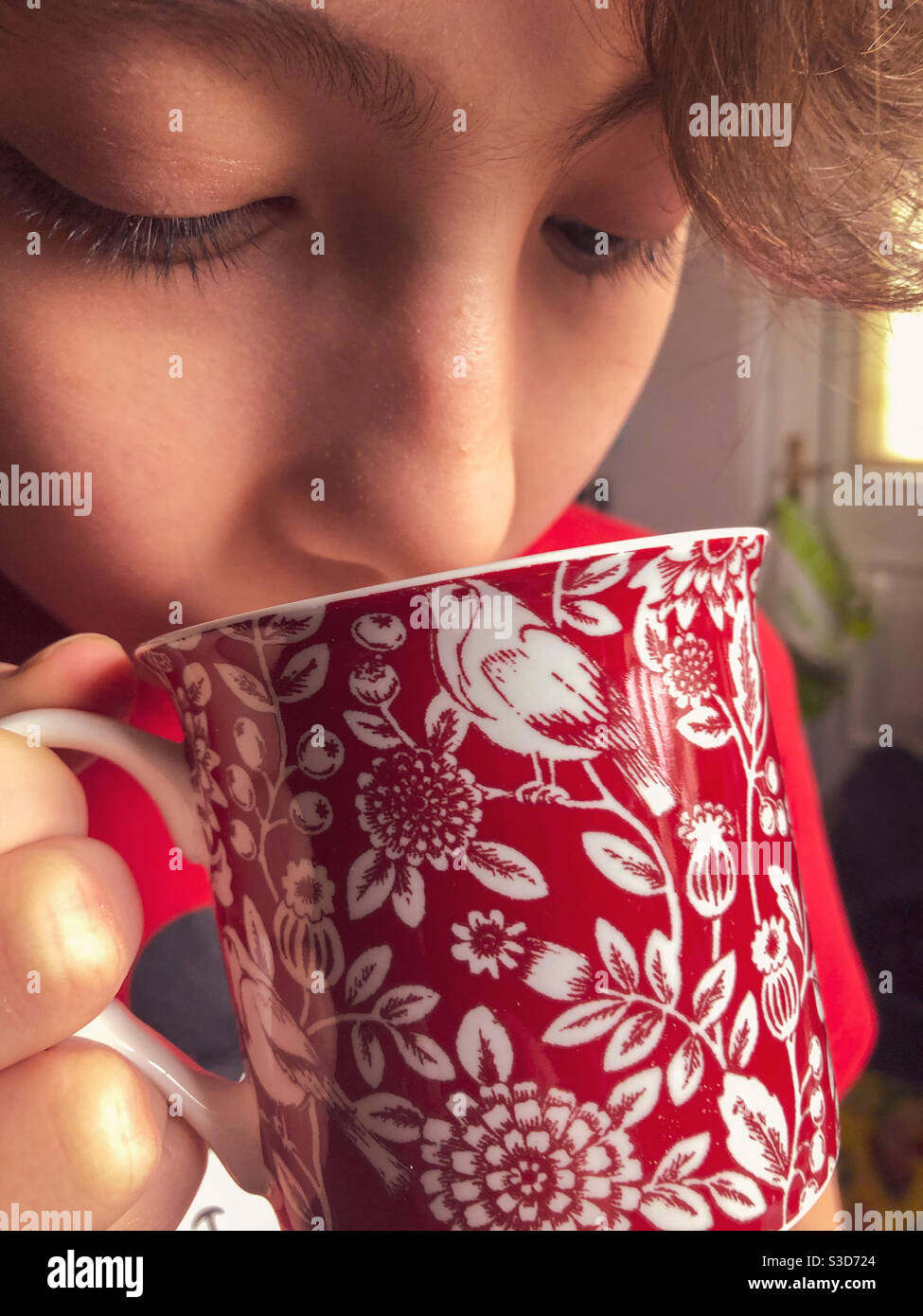 Primo piano di un ragazzo che beve da una tazza. Foto Stock