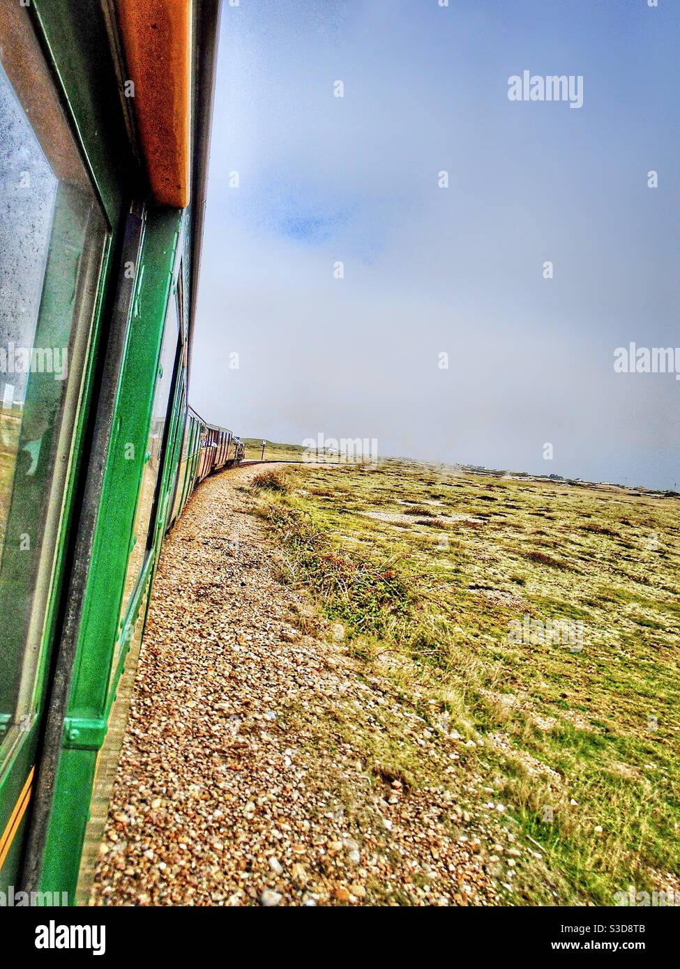 Tutti a bordo! Un treno leggero Romney, Hythe e Dymchurch che si dirige lungo la pista verso Dungeness, Kent, Inghilterra. Foto Stock