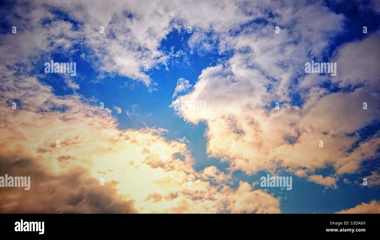 Una fotografia di belle nuvole bianche soffici contro un cielo blu vivido. Sole, sfondo tranquillo e tranquillo. Foto Stock