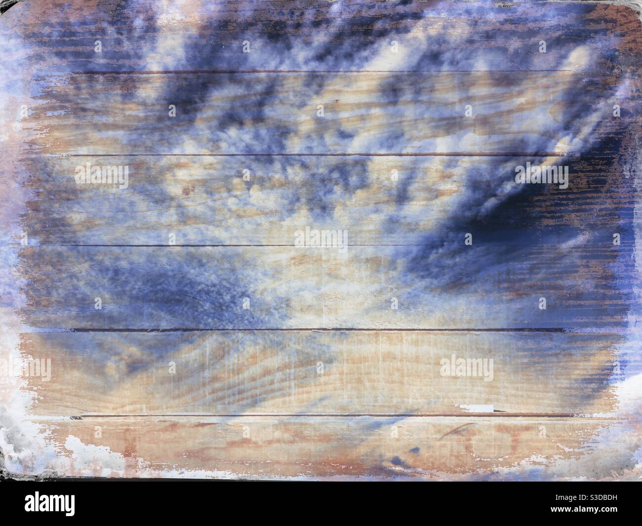 Cielo blu denim con nuvole bianche sovrapposte a un legno sfondo Foto Stock