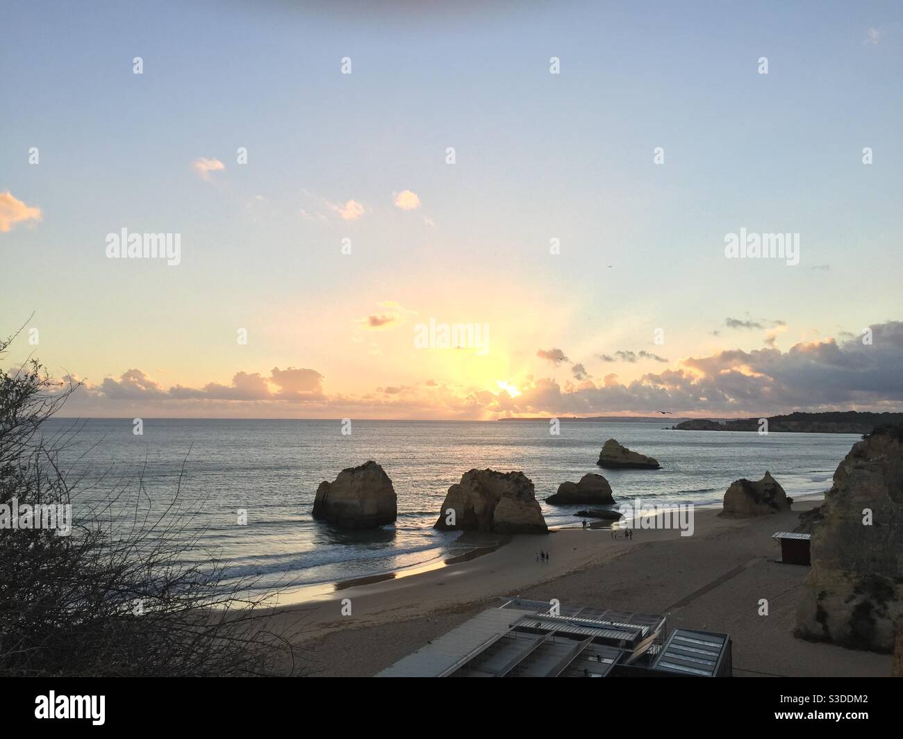 Un bel tramonto in una grande spiaggia di sabbia con rocce In Portogallo Foto Stock
