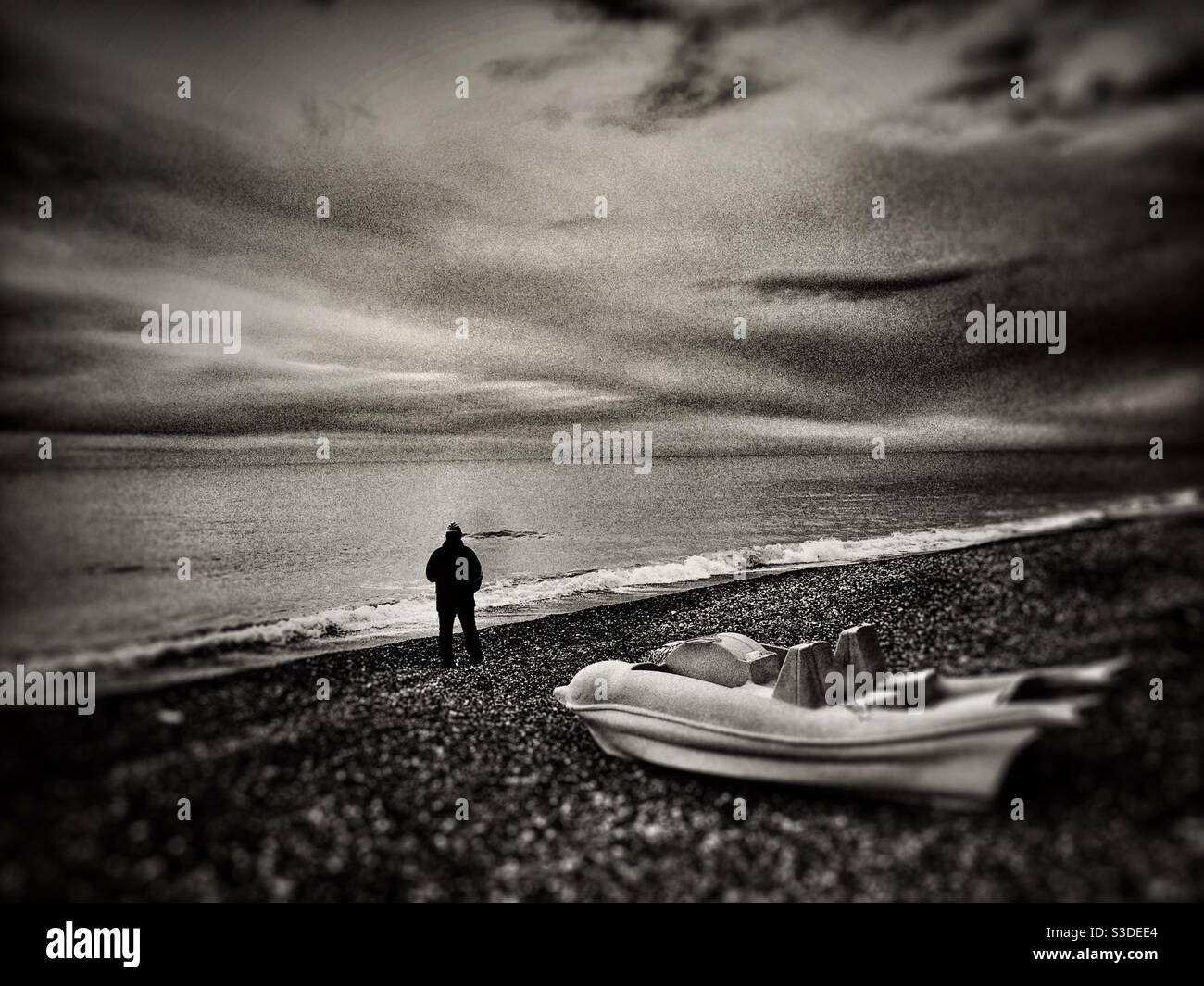 Spettacolare vista mare con una barca e un uomo in piedi vicino al mare Foto Stock