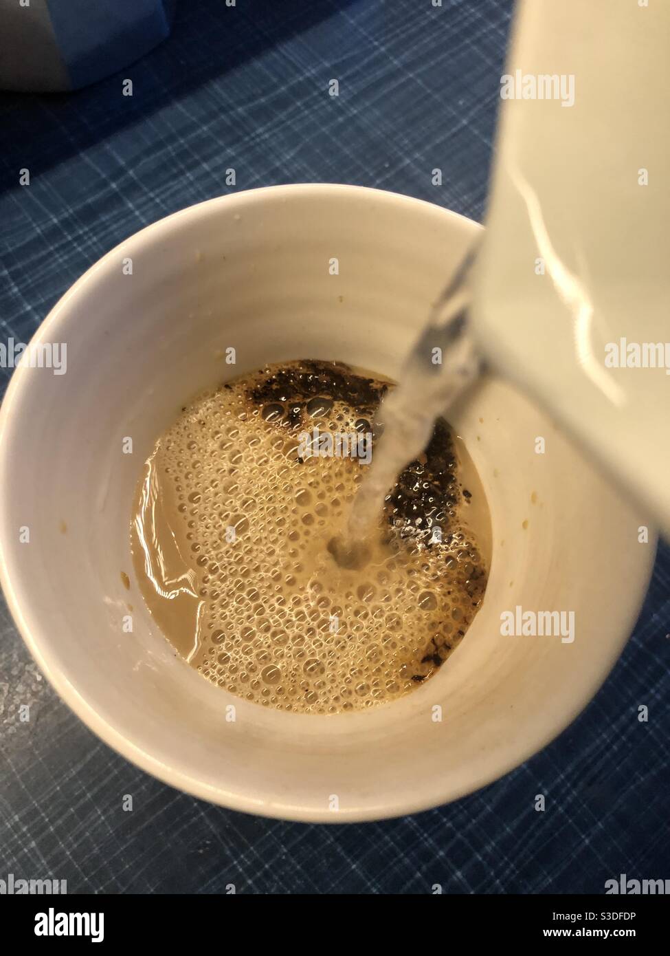 Versare acqua bollente per preparare un caffè istantaneo - Immagine stock catturata con smartphone
