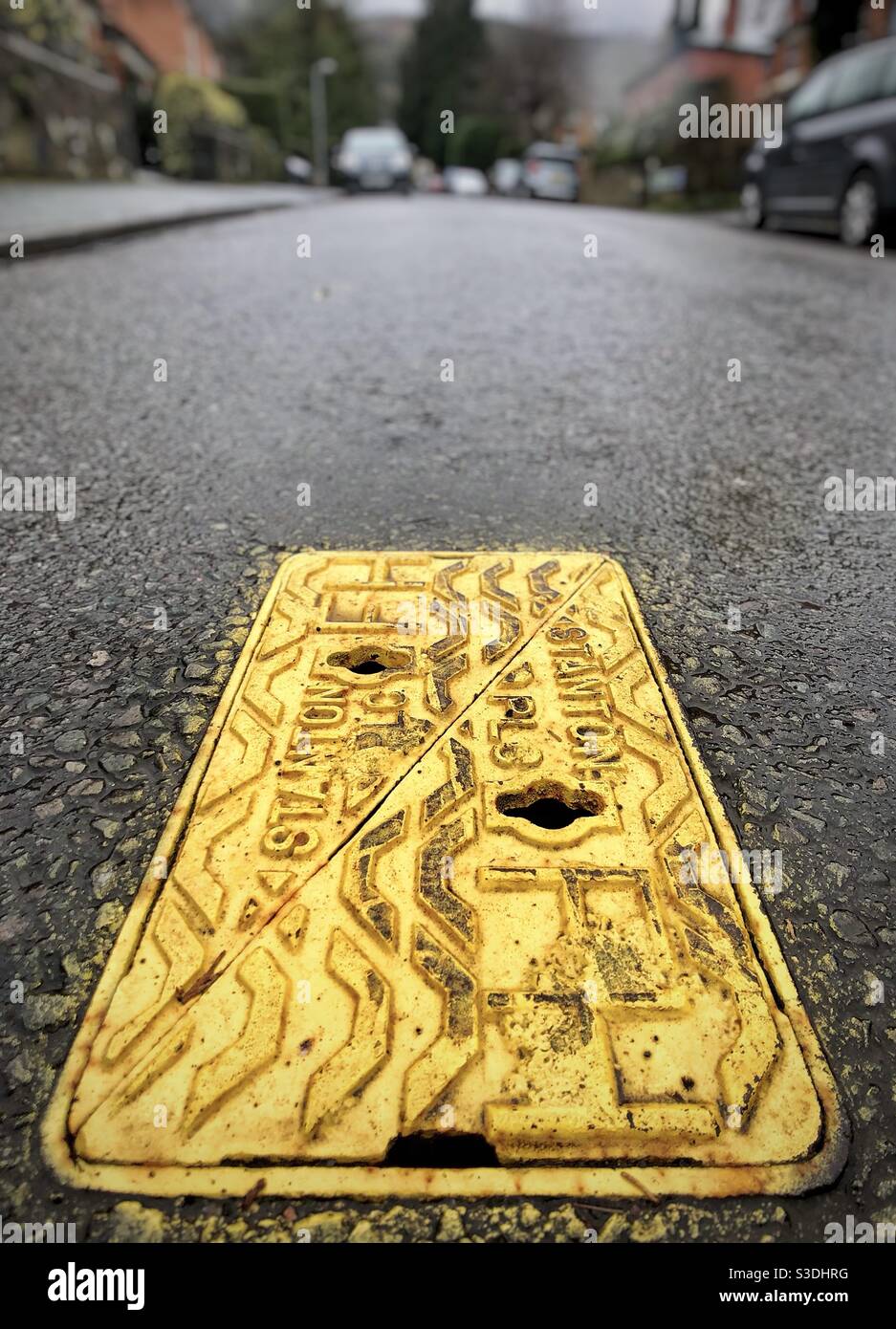 Coperchio di ispezione giallo su strada Foto Stock