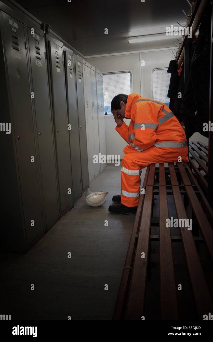 Un lavoratore di sesso maschile o un lavoratore che soffre sul lavoro con salute mentale, dolore o malattia Foto Stock