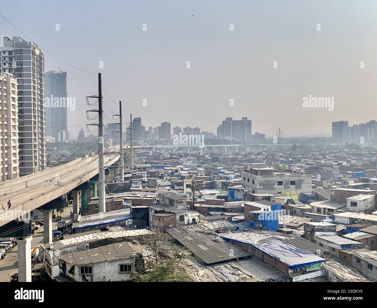 Vista sulla città, con linee metropolitane che separano baraccopoli ed edifici, intorno a Malad, Mumbai Foto Stock