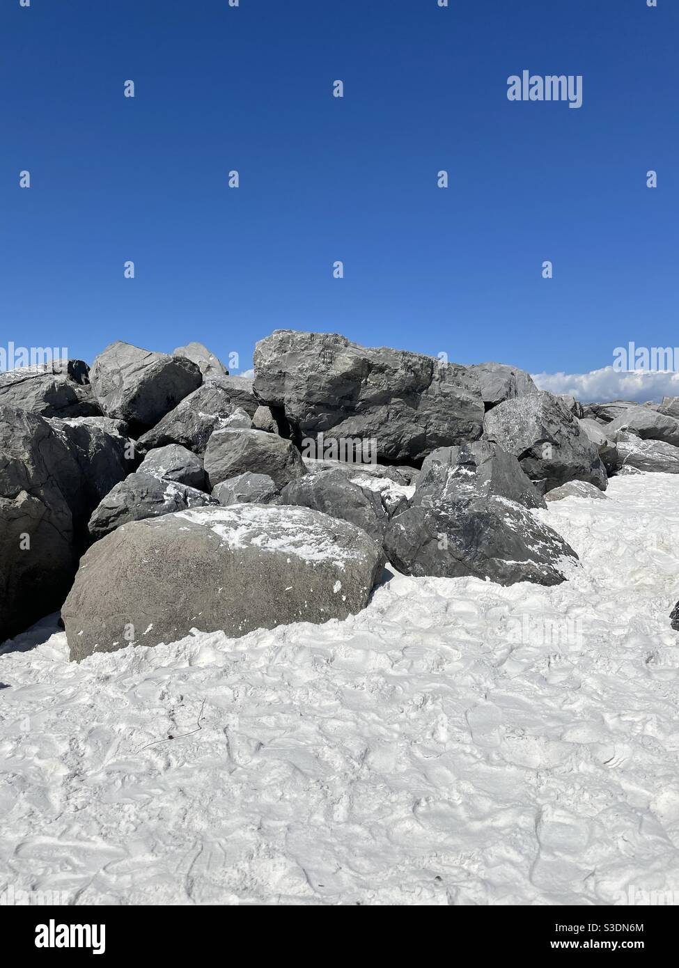 Molo roccioso sulla spiaggia di sabbia bianca della Florida con cielo blu Foto Stock