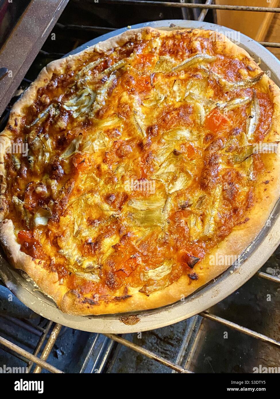 Pizza fresca fatta in casa con acciughe e cuori di carciofi. Atlanta, Georgia: 1 marzo 2021 Foto Stock