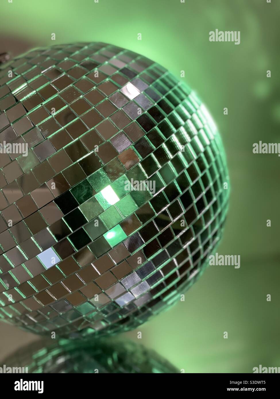 Disco palla con illuminazione verde su superficie specchiata Foto Stock