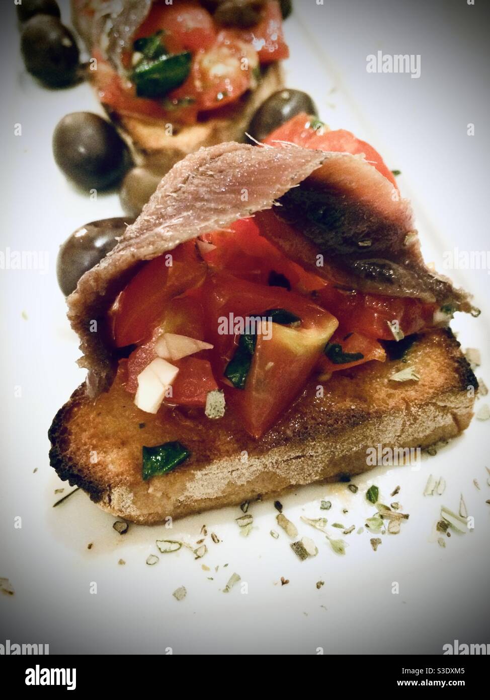 Gustosa bruschetta con pesce affumicato, pomodori e olive Foto Stock