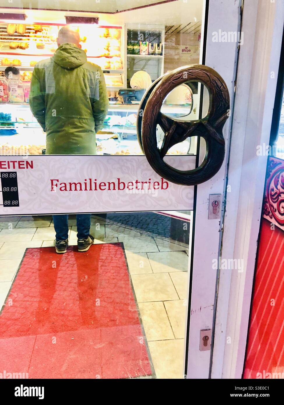 Maniglia per porta a forma di pretzel su una panetteria a Berlino in Germania - Immagine stock catturata con smartphone